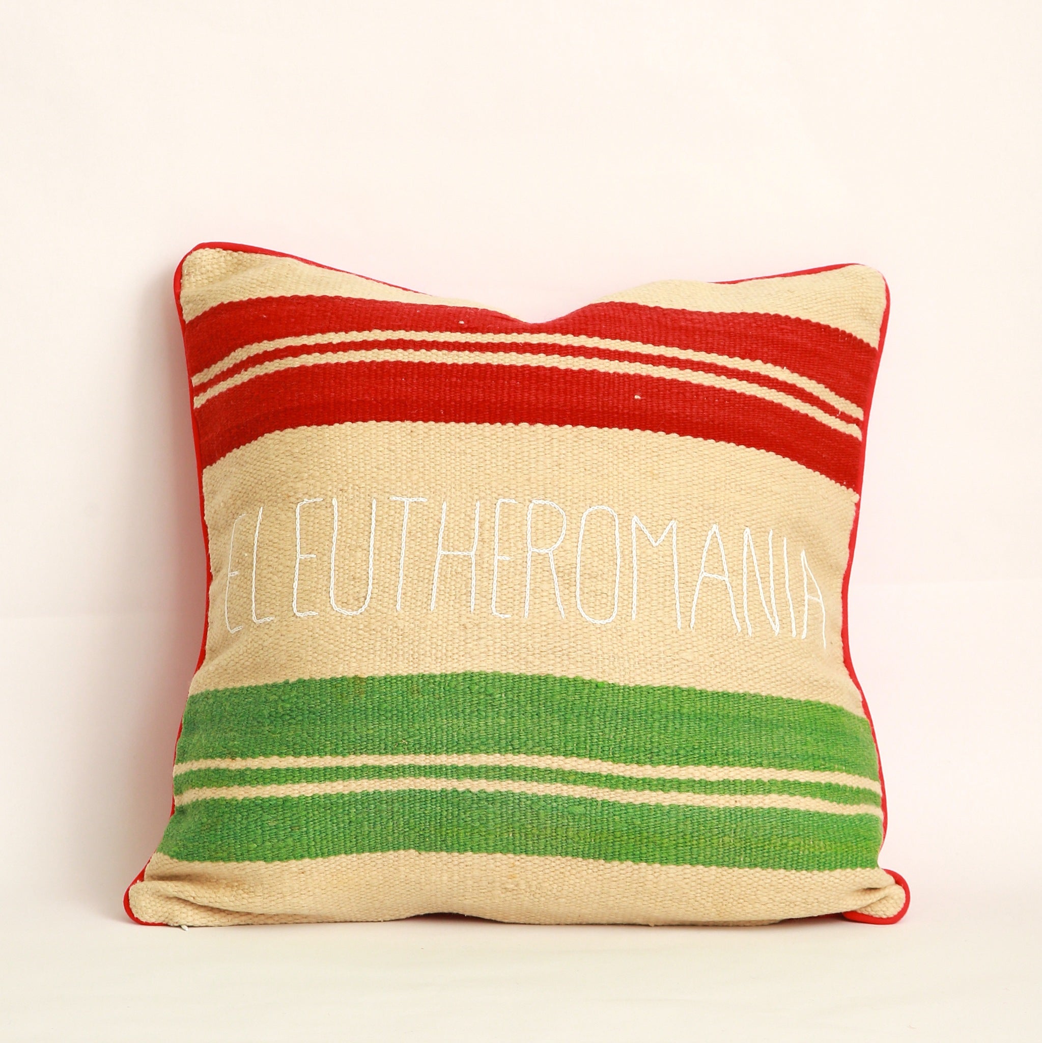Copricuscino realizzato con due tessuti diversi, uno da ogni lato, Coperta in lana vintage tessuta a mano nell'Alto Atlante, bianco avorio, a righe colorate rosso e verde e cucita con velluto rosso - Piping rosso 100% cotone certificato OEKO-TEX® con parola greca Eleutheromania ricamata a mano