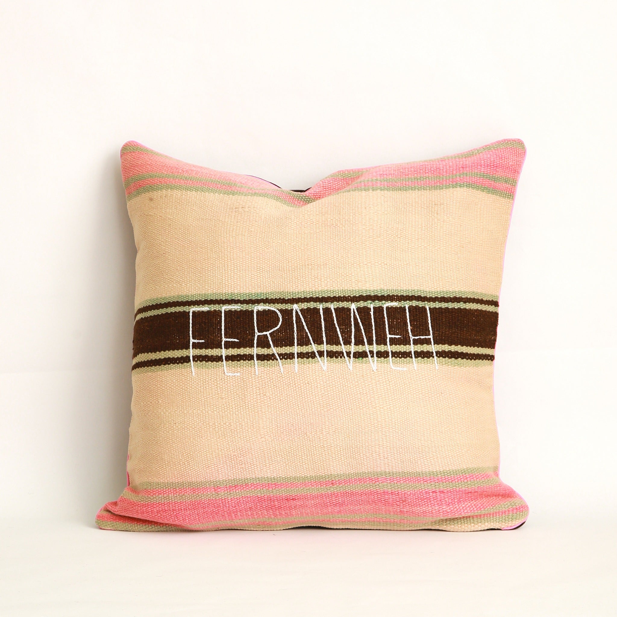 Cuscino realizzato in 2 tessuti, uno diverso da ogni lato: Coperta in lana vintage a righe tessuta a mano nell'Alto Atlante cucita con velluto marrone tinta unita dall'altro lato - Piping rosa chiaro 100% cotone certificato OEKO-TEX®, fronte ricamato a mano con la parola Fernweh