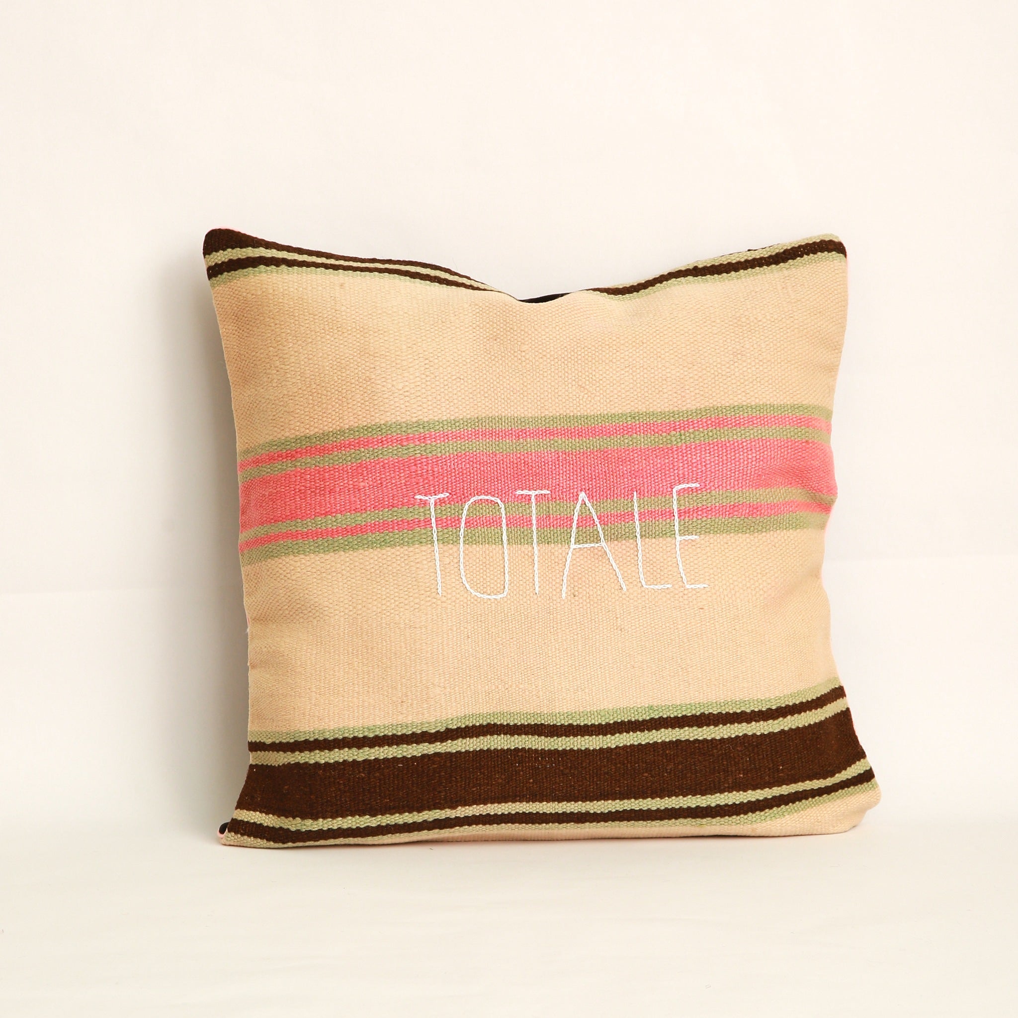 Cuscino realizzato in 2 tessuti, uno diverso da ogni lato: Coperta in lana vintage a righe tessuta a mano nell'Alto Atlante cucita con velluto marrone tinta unita dall'altro lato - Piping rosa chiaro 100% cotone certificato OEKO-TEX®, fronte ricamato a mano con la parola Totale