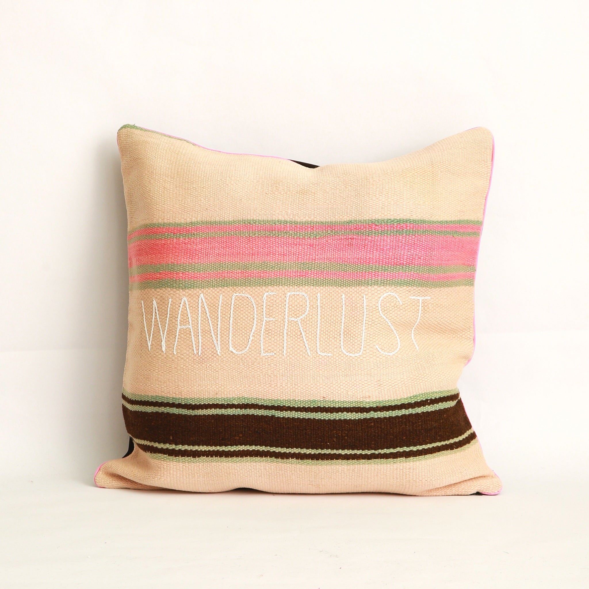 Cuscino realizzato in 2 tessuti, uno diverso da ogni lato: Coperta in lana vintage a righe tessuta a mano nell'Alto Atlante cucita con velluto marrone tinta unita dall'altro lato - Piping rosa chiaro 100% cotone certificato OEKO-TEX®, fronte ricamato a mano con la parola Wanderlust