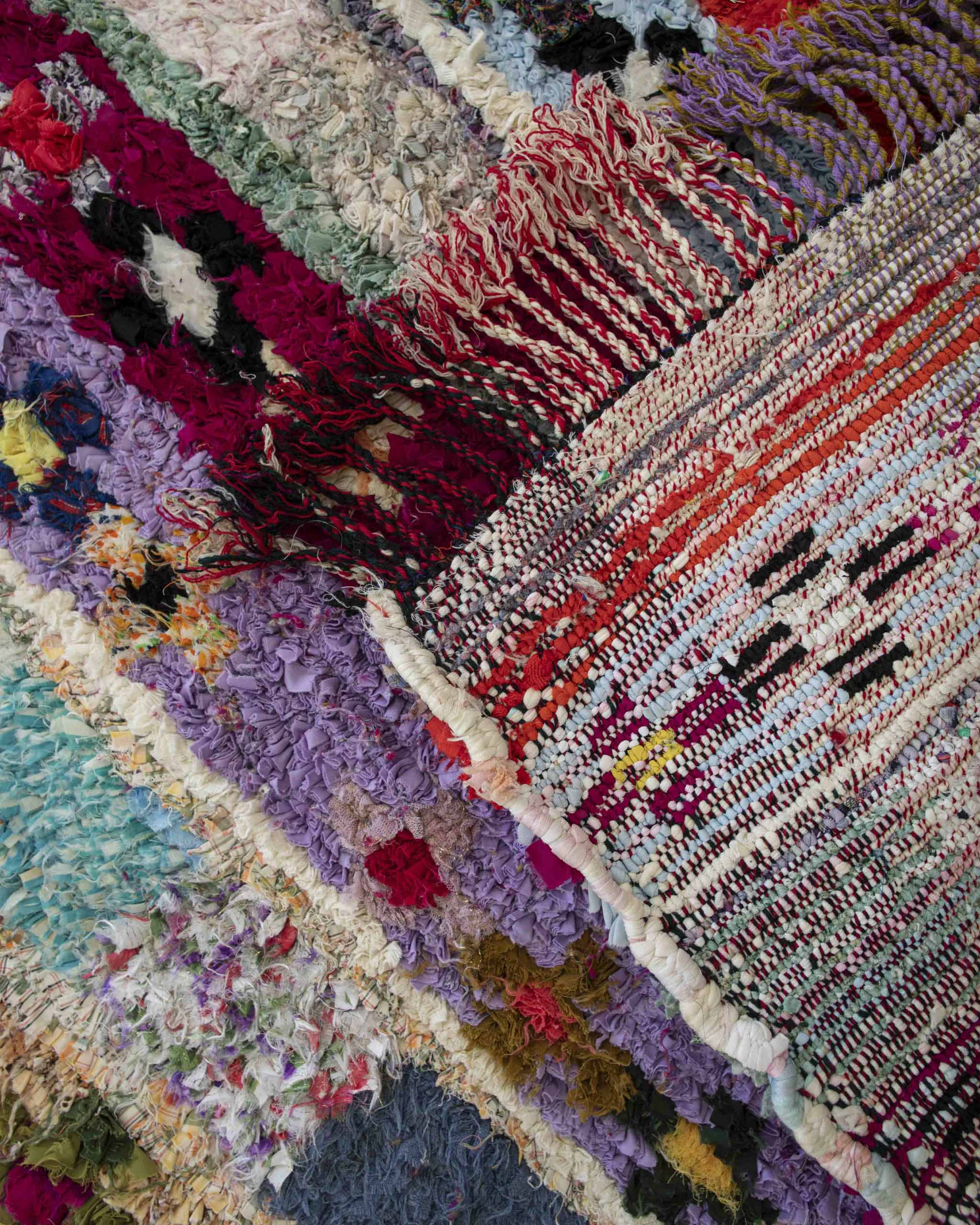 dettaglio retro tappeto con fettucce di tessuti multicolore annodati e france intrecciate