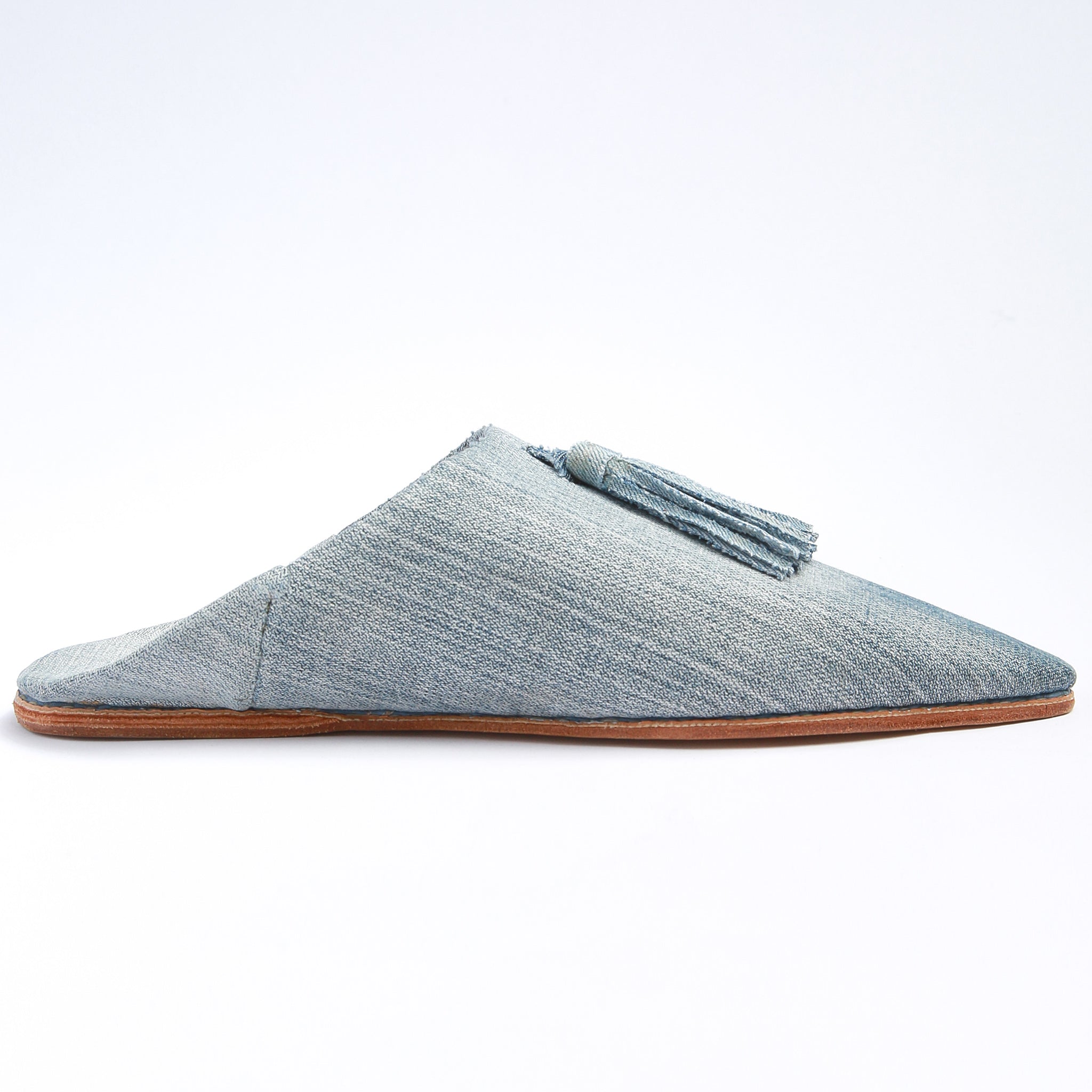 babouche realizzata a mano in marocco in jeans chiaro con pompon in jeans vista dal lato