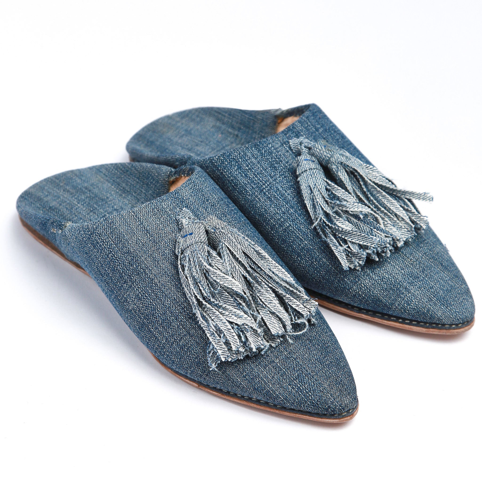 coppia di babouche marocchine in denim con pompon viste frontalmente