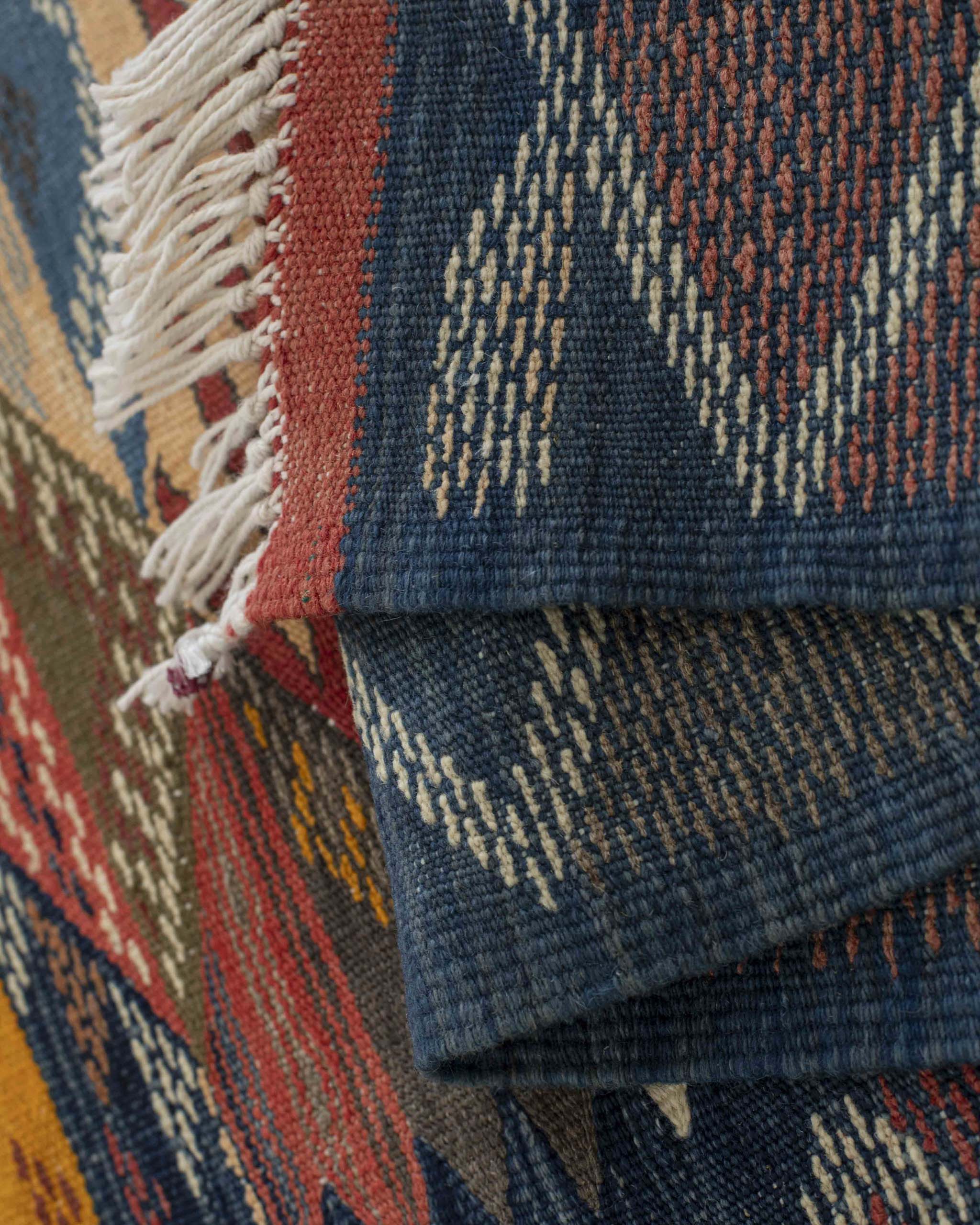 Dettaglio dritto-rovescio della bordatura annodata a mano del tappeto kilim Kharita artigianale