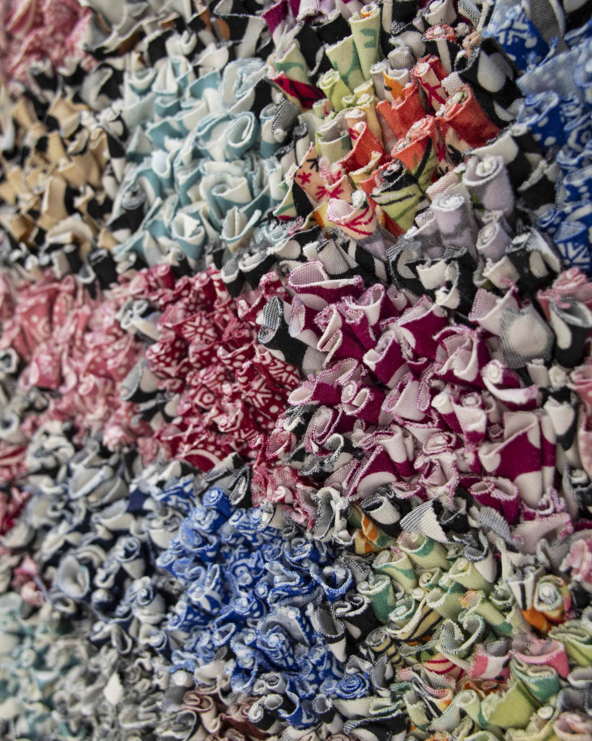 Dettaglio del Boucherouite annodato a mano con tessuti riciclati stampati e texture puntinata multicolore
