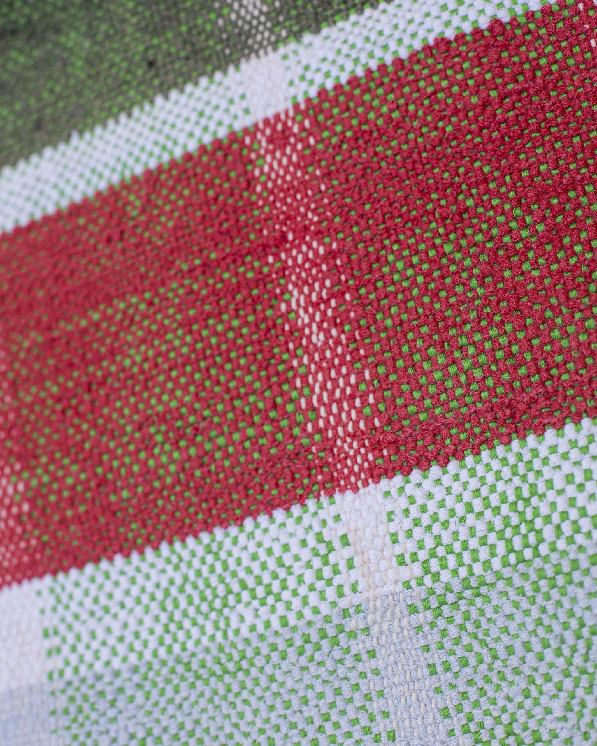 Dettaglio del cuscino tessuto a mano a quadri verde, bianco, rosso