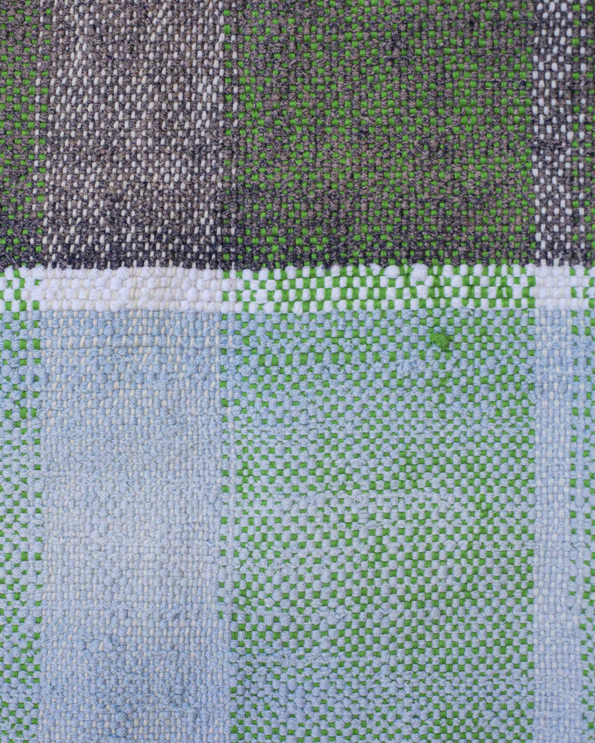 Dettaglio del tessuto fatto a mano a quadri tono su tono verdi, grigi, azzurri