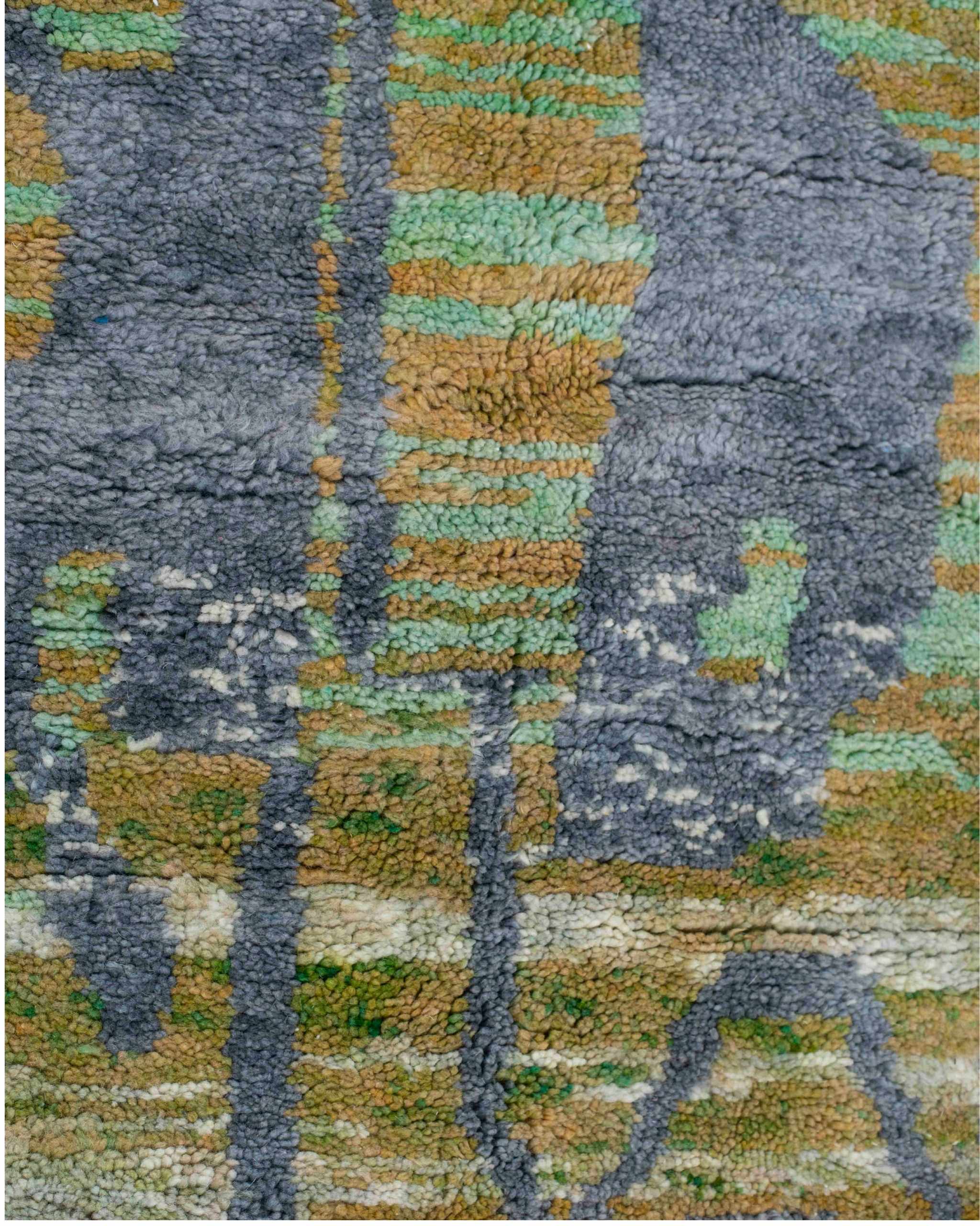 Dettaglio del disegno astratto grigio su fondo a righe irregolari verdi del tappeto berbero Beni Ourain in pura lana