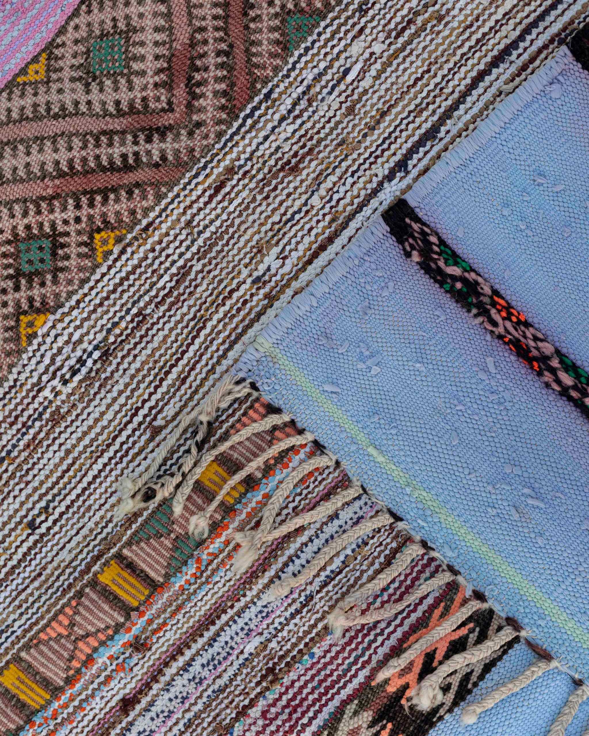 Dettaglio delle frange e dei disegni del tappeto boucherouite vintage in tessuti riciclati multicolore