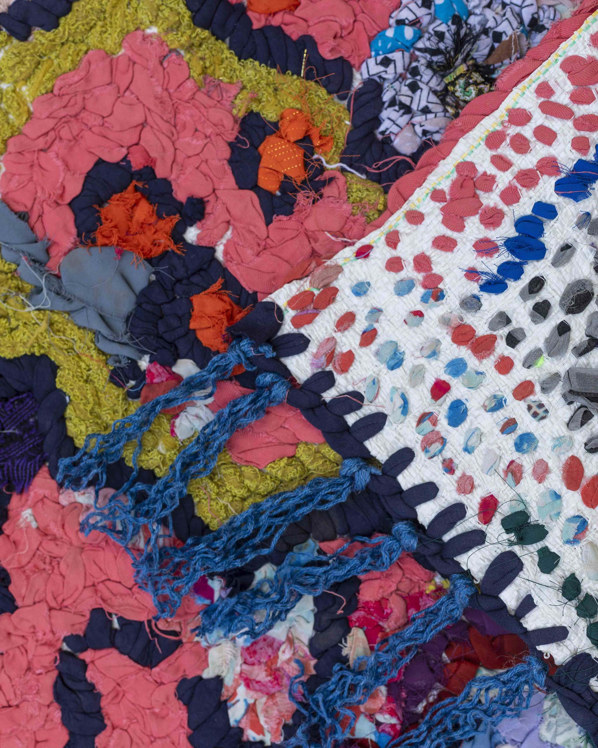 Dettaglio fronte retro del tappetino d'arte tessile in strisce di stracci annodati a mano su base in plastica riciclata da sacchi alimentari