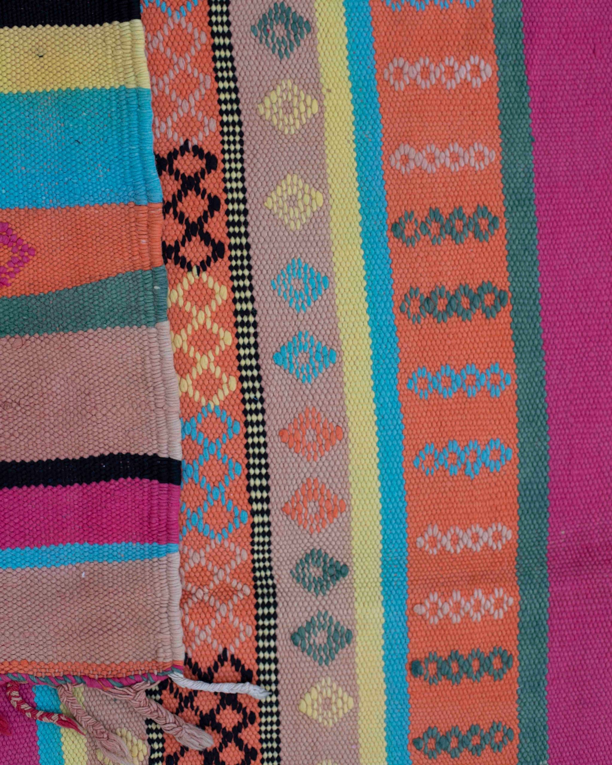 Dettaglio dei micro motivi geometrici tessuti a mano sulla passatoia Azilal a righe colorate