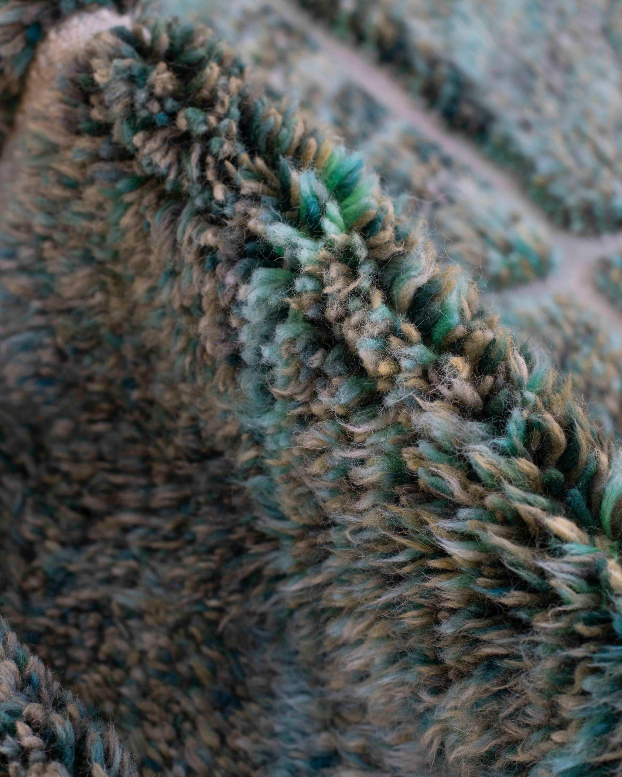 Dettaglio del vello del tappeto Beni Ourain in lana con filati melange blu, verdi, beige