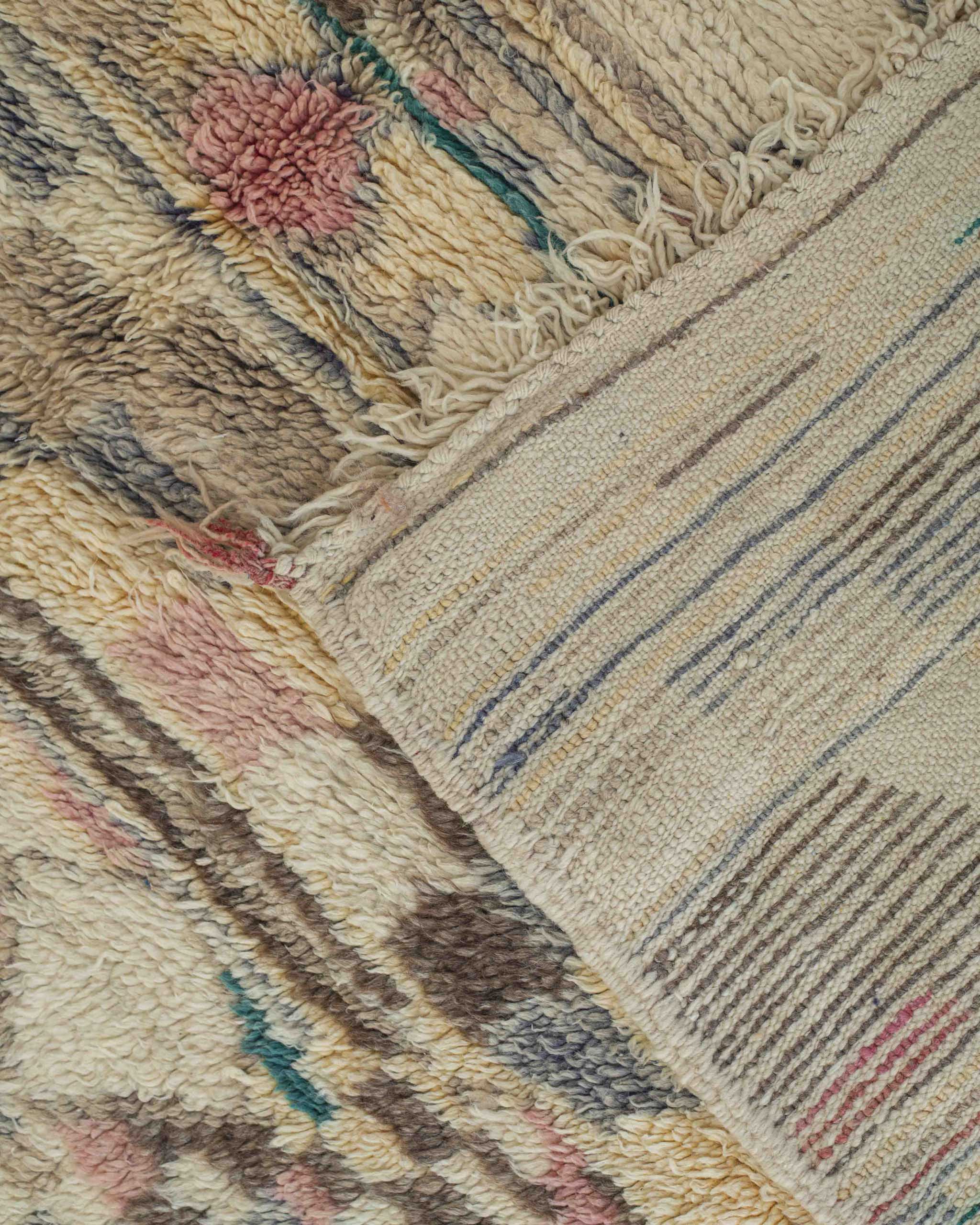 Dettaglio del rovescio del tappeto con bordi e cimose annodate a mano piccole frange e trama a vista