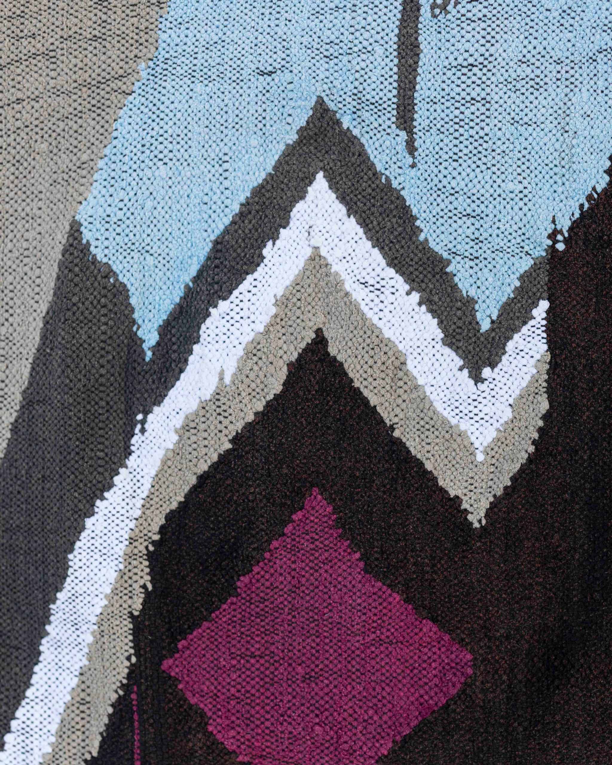 Dettaglio del rombo viola, del zigzag e delle linee del tappeto boucherouite in grigio, bianco e azzurro chiaro