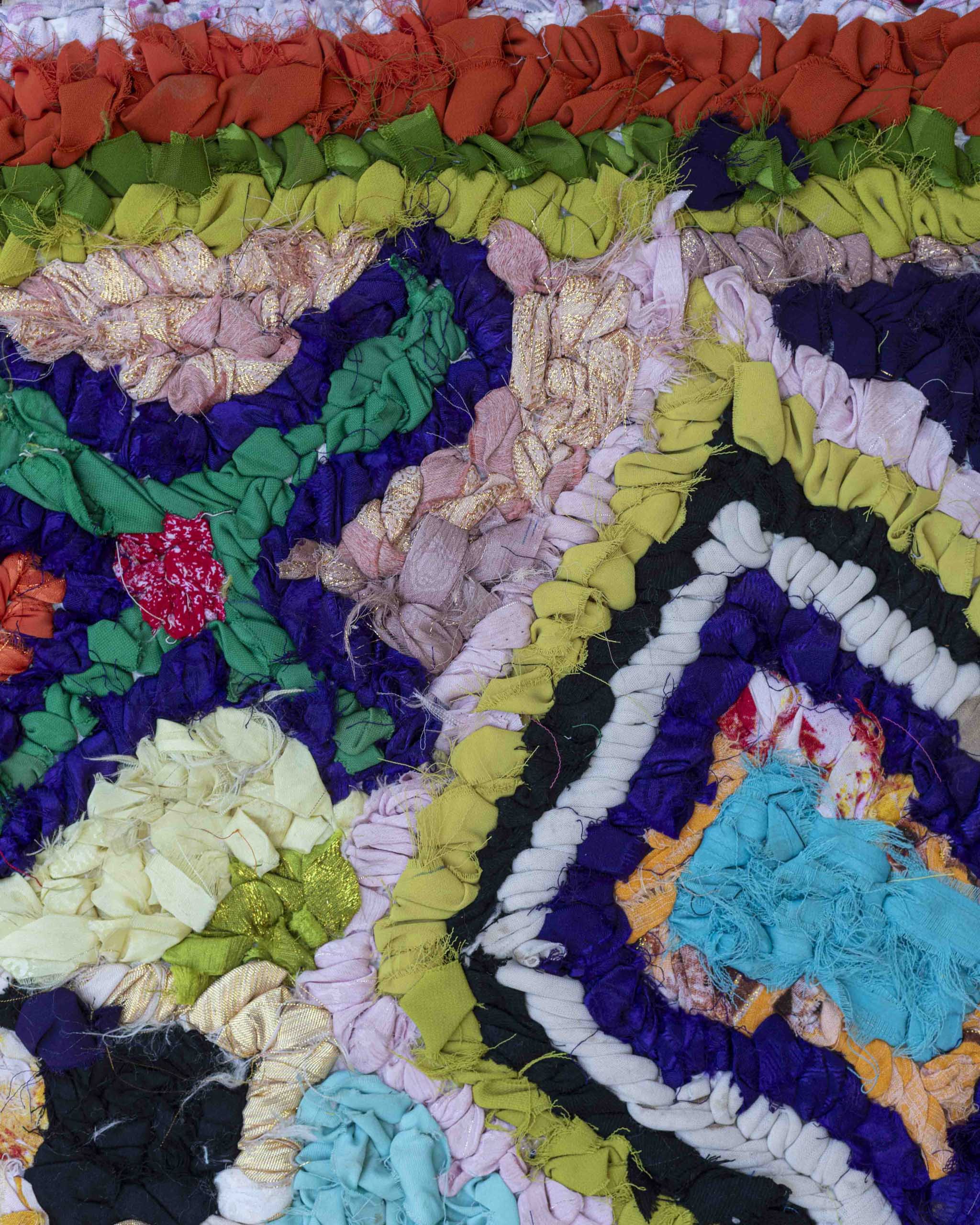 Dettaglio dei tessuti usati per la creazione del tappetino di stracci in colori accesi e fantasia astratta
