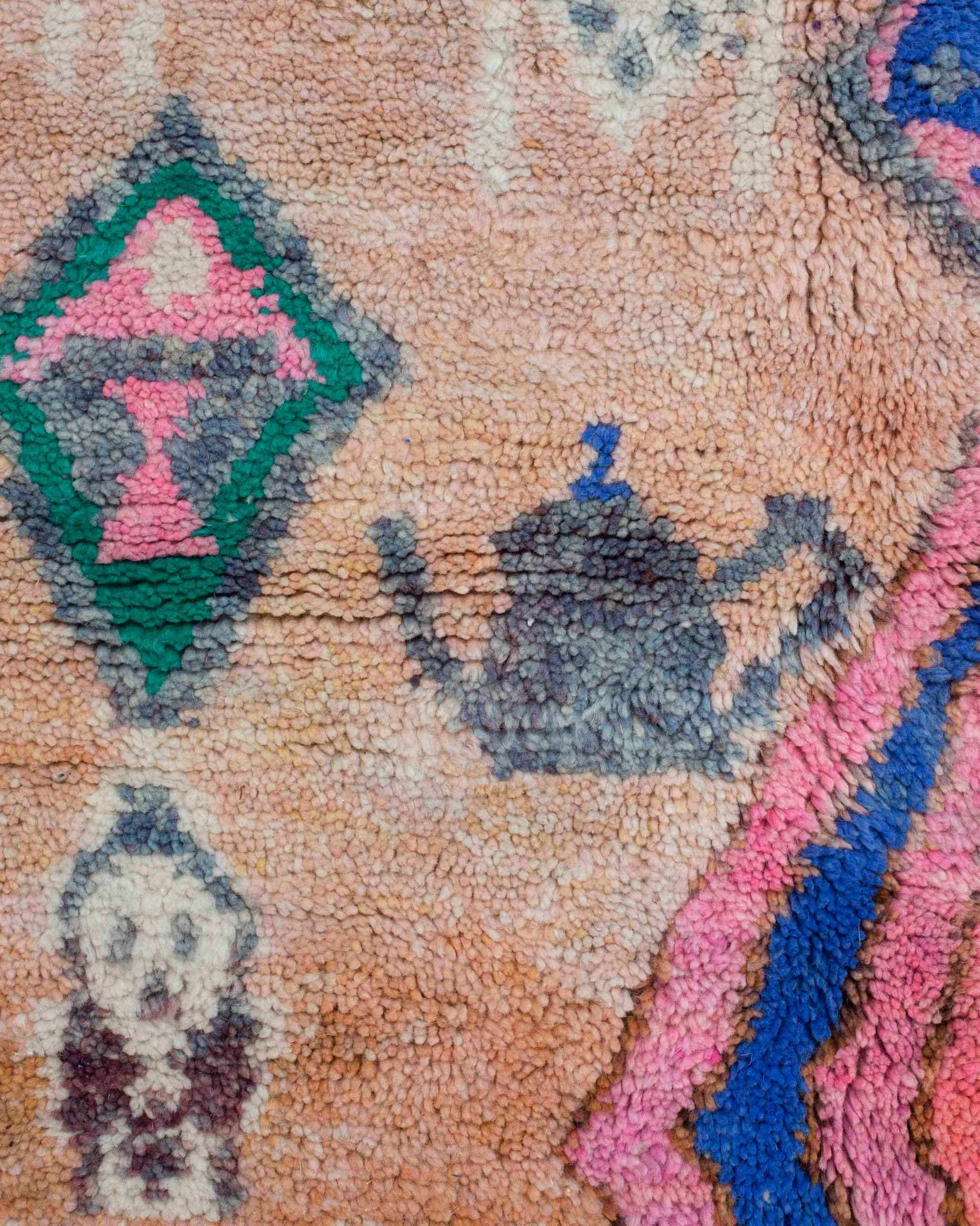 Dettaglio delle teiere stilizzate grigie e dei motivi colorati del tappeto berbero Beni Ourain