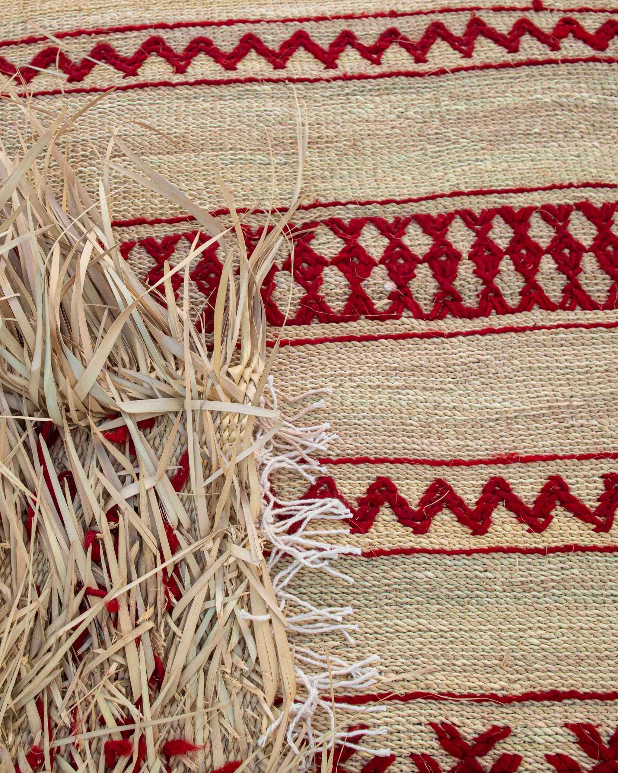 dettaglio stuoia in paglia intrecciata a mano con decori geometrici berberi