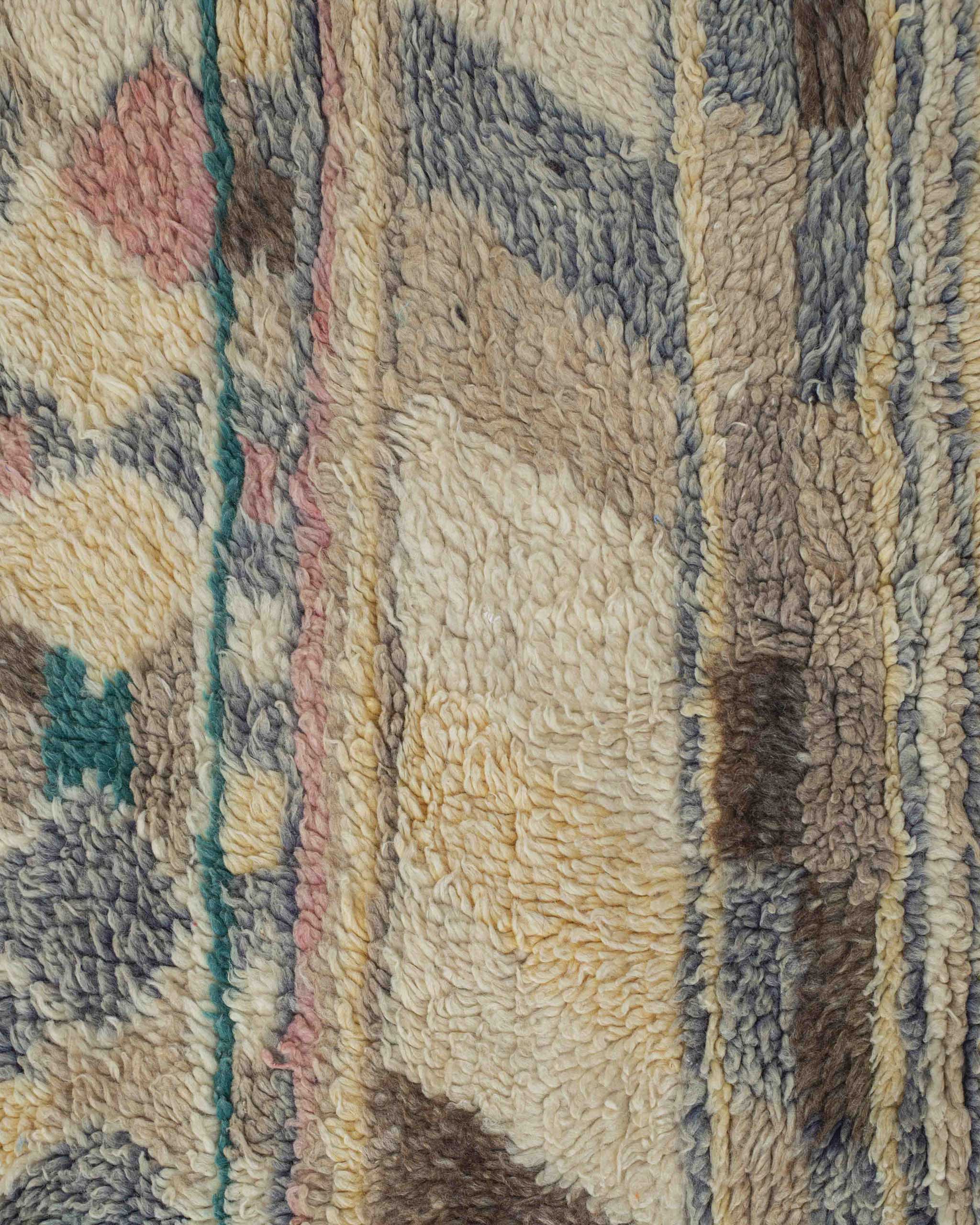 Dettaglio del tappeto in lana a pelo corto con rombi e scacchi grigio rosa verde marrone