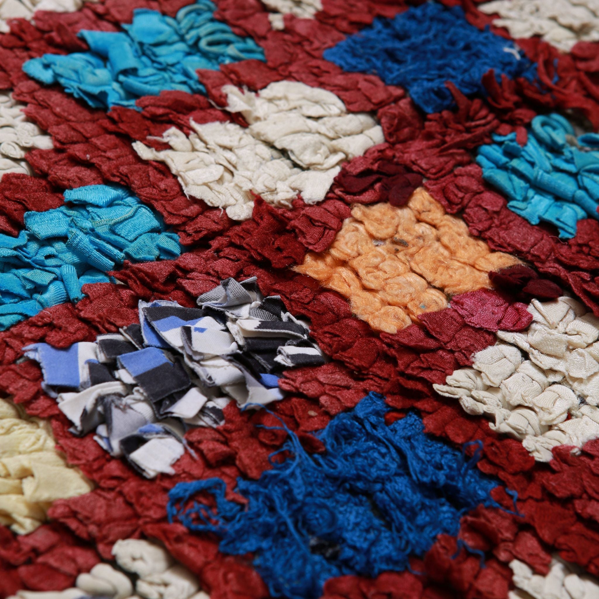 Pattern geometrico colorato di tappeto Boucherouite berbero sostenibile con tessuti e filati riciclati in rosso, bianco e varie tonalità di azzurro