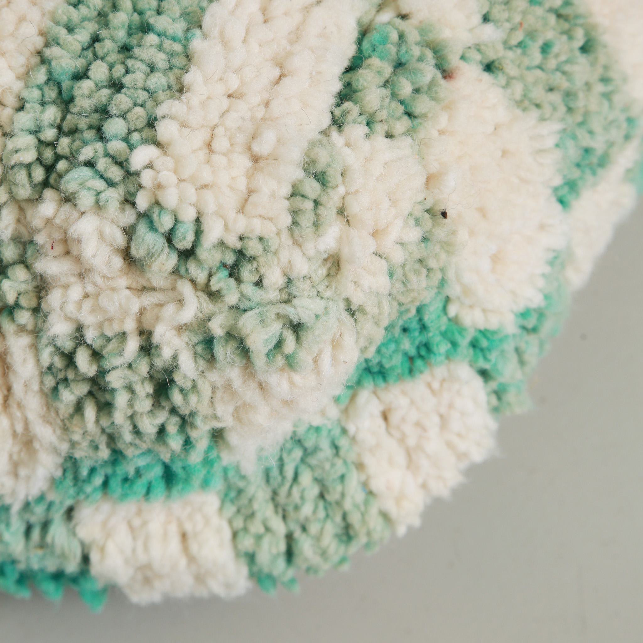 Dettaglio texture lana vergine marocchina del pouf artigianale con pattern a scacchi verde menta e avorio