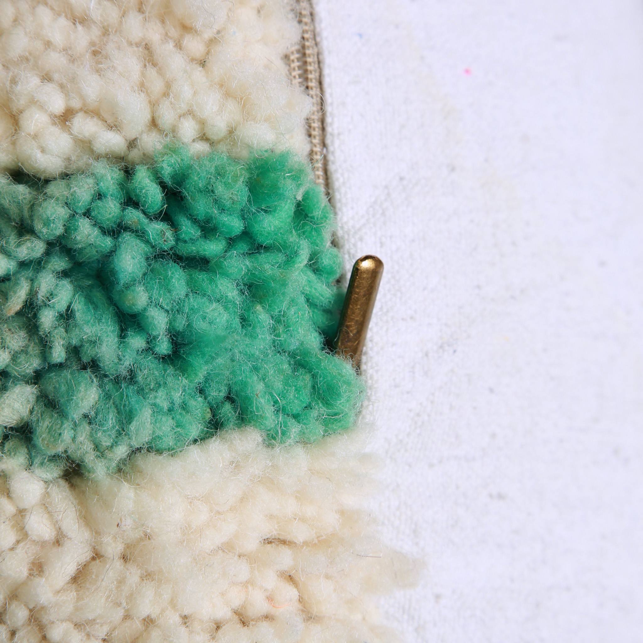 Dettaglio chiusura in ottone del pouf marocchino verde menta in lana annodato a mano