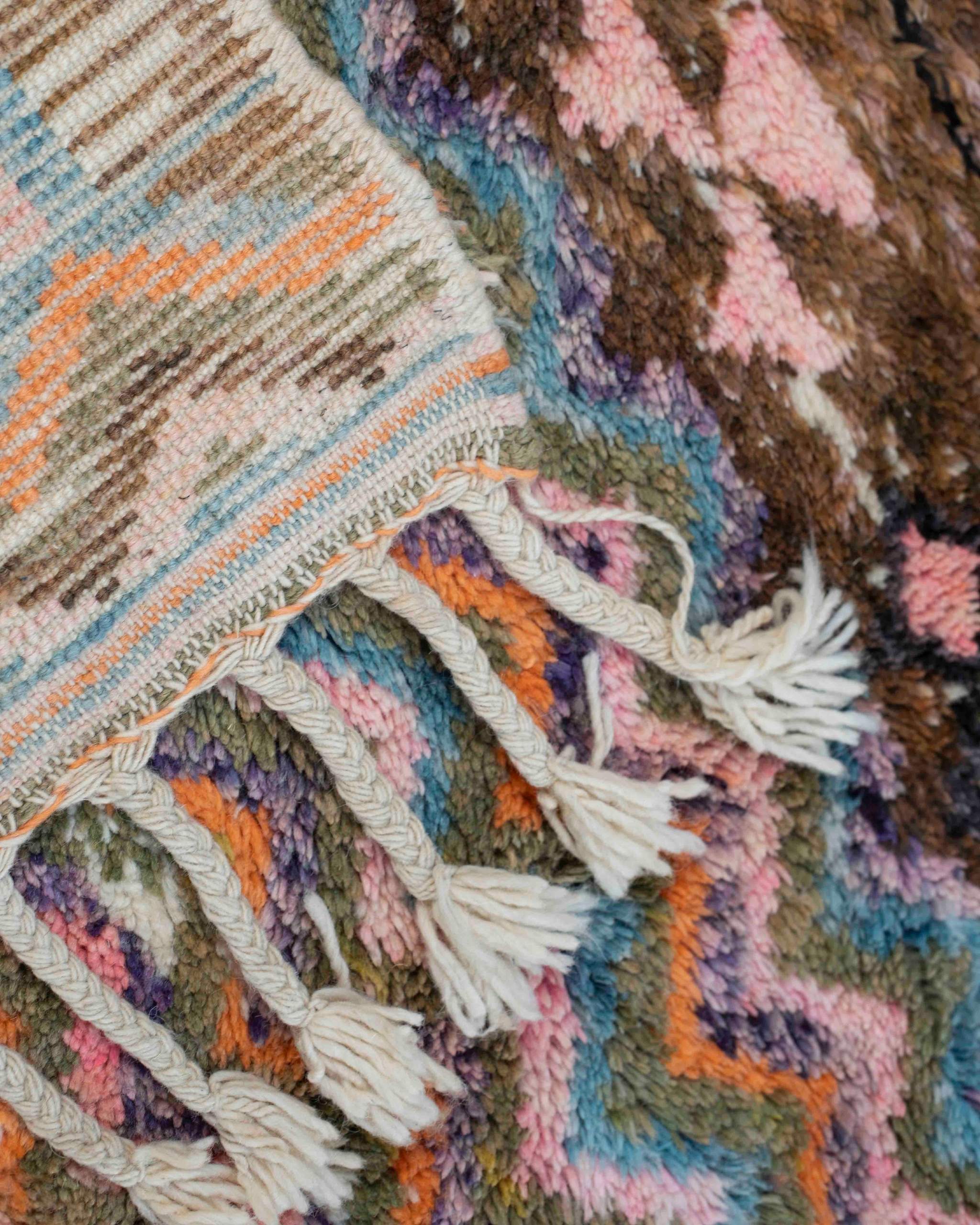 Dettaglio fronte-retro del tappeto Beni Ourain annodato a mano in lana multicolore fantasia zigzag, frange intrecciate a mano