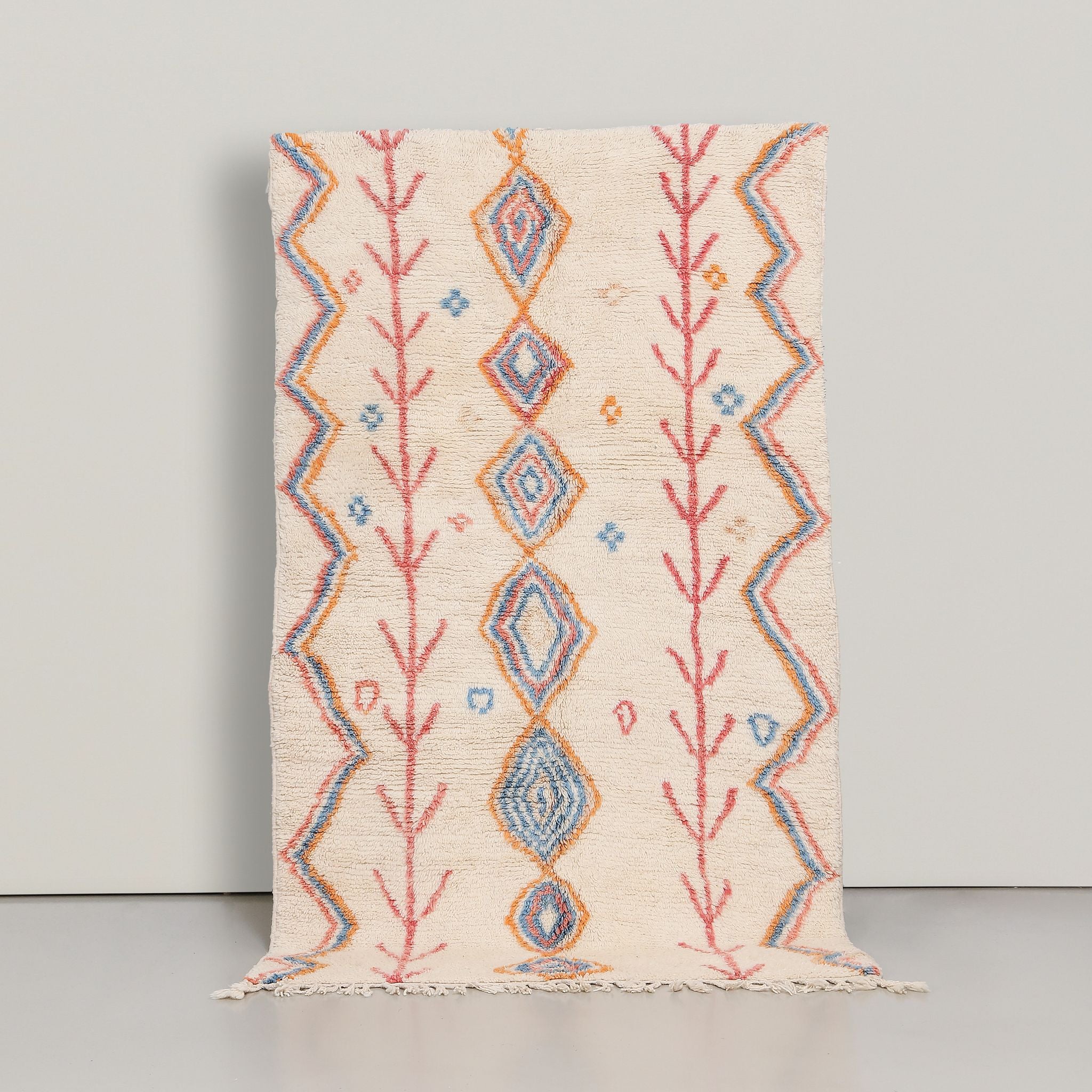 tappeto marocchino in lana con serie di rombi colorati centrali e linee a zig zag laterali