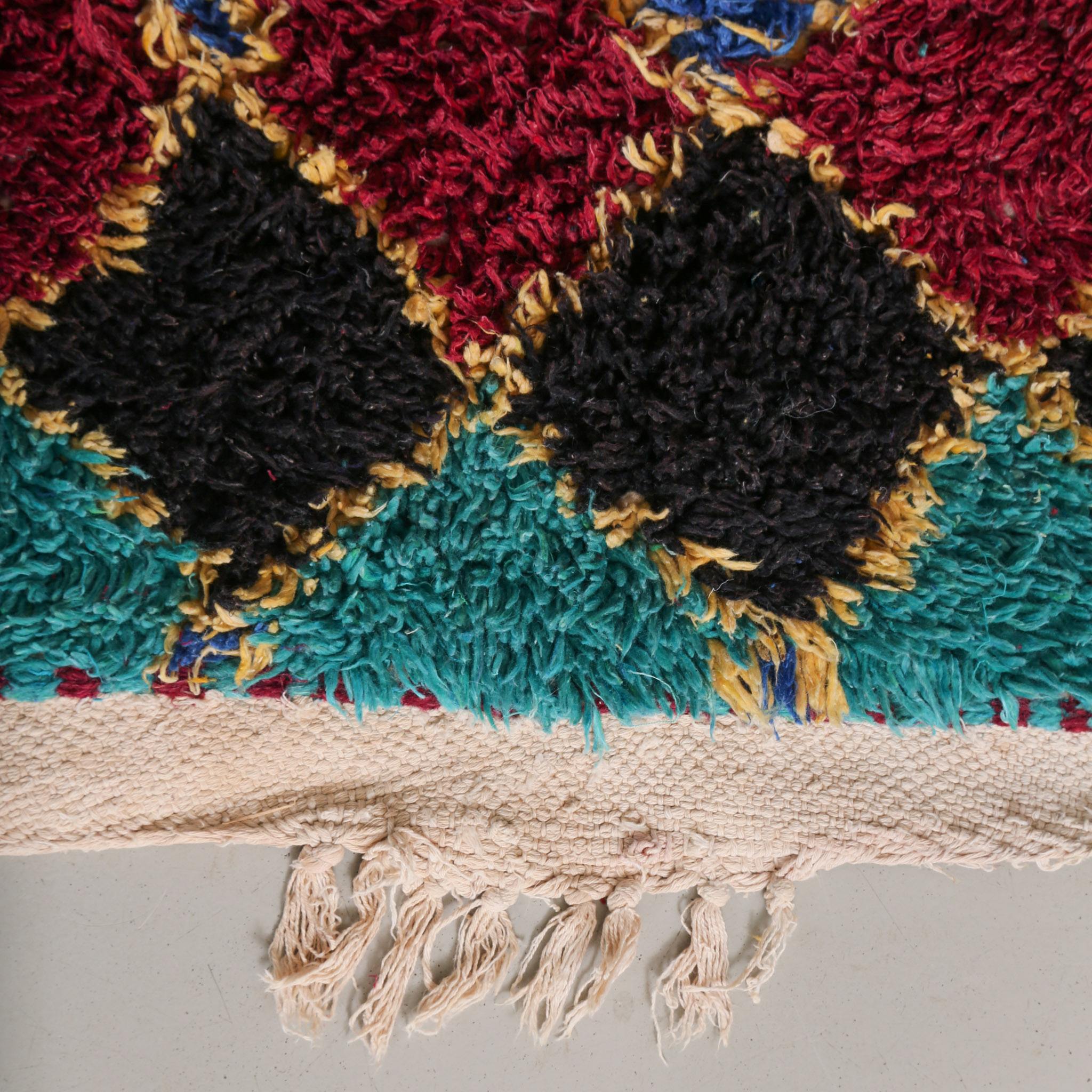 Dettaglio della base in cotone naturale e frange del tappeto Azilal vintage, testimonianza dell'artigianato sostenibile marocchino