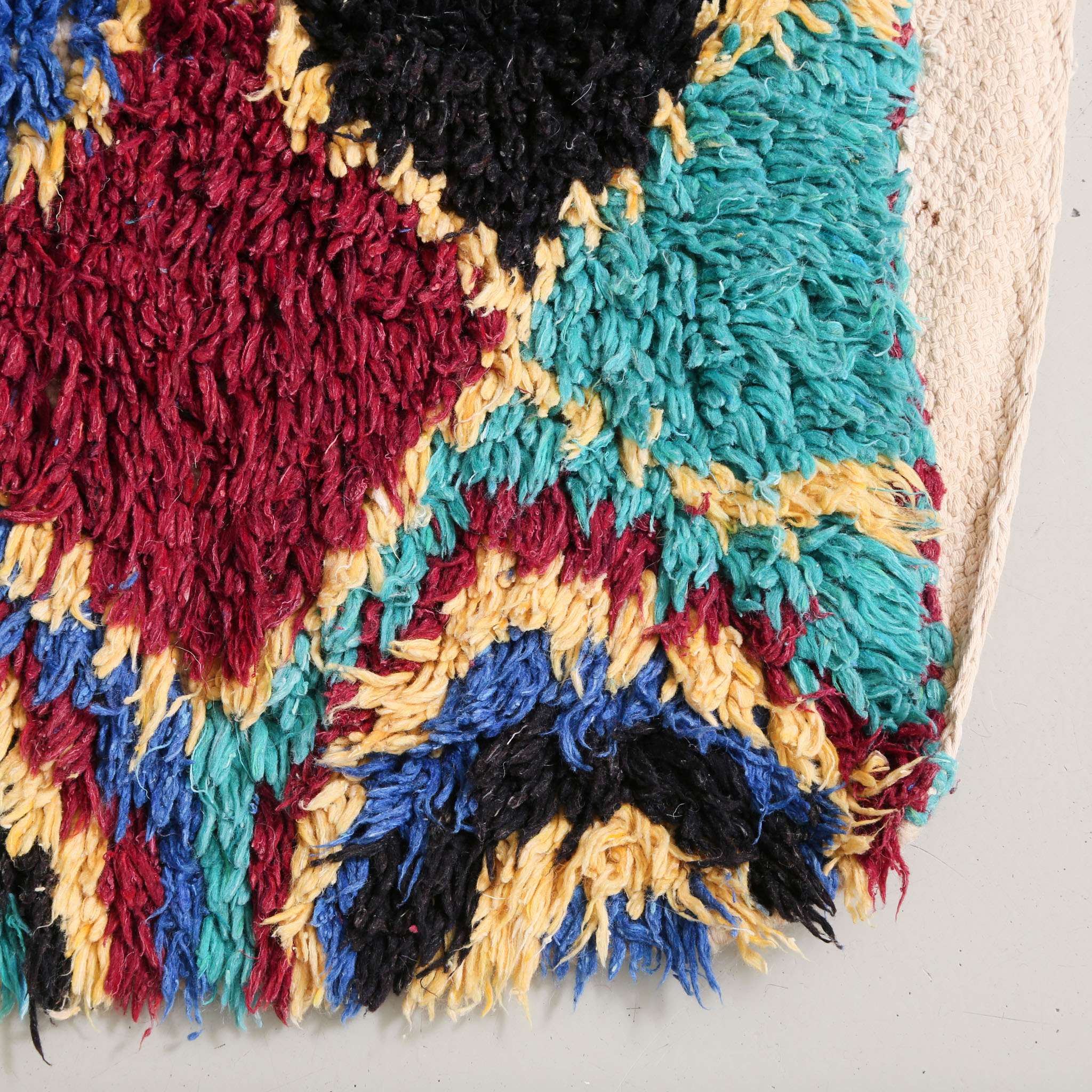 Dettaglio della lavorazione in lana a pelo alto del tappeto Azilal vintage, pattern a rombi con colori vivaci e bordi sfrangiati caratteristici