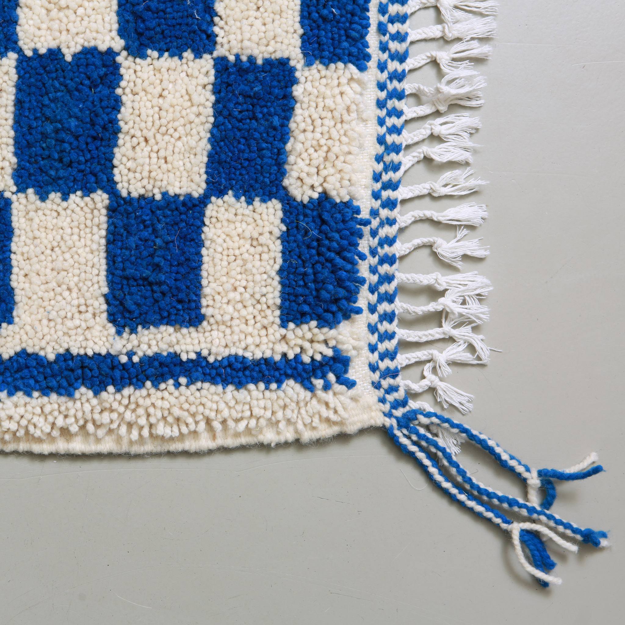 Dettaglio della tessitura geometrica della passatoia marocchina Azilal con pattern a scacchi blu