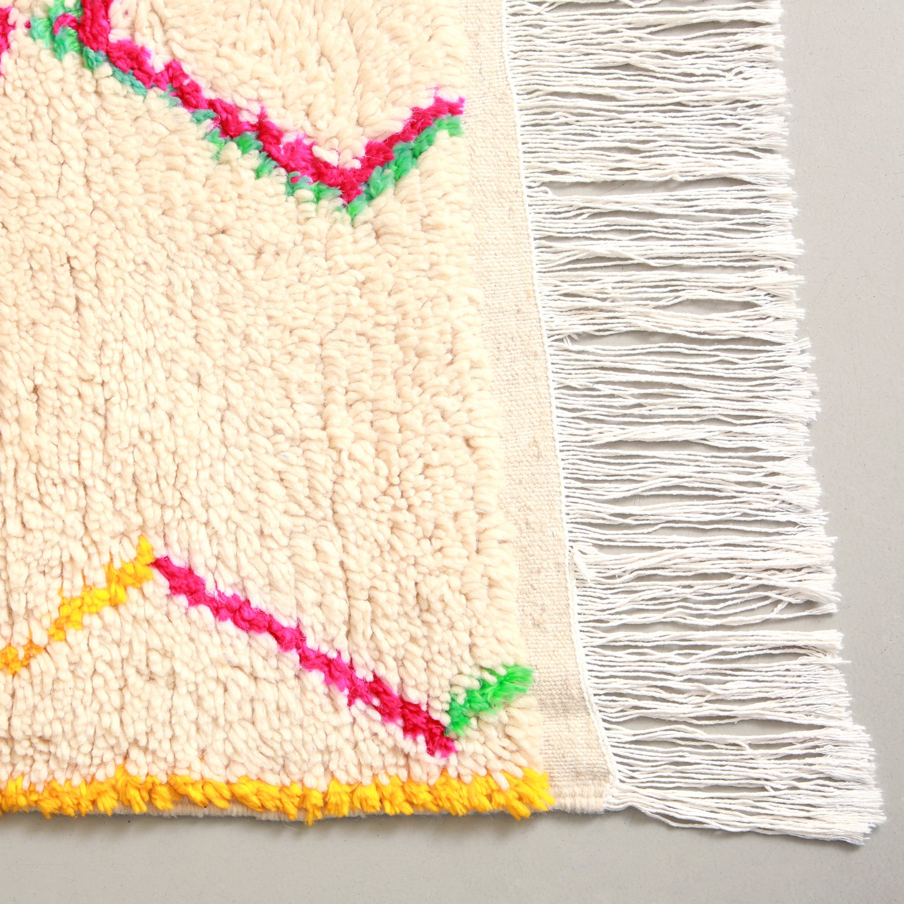 dettaglio dell'angolo con pelo corto e frangia sottile e lunga di un tappeto marocchino azilal 