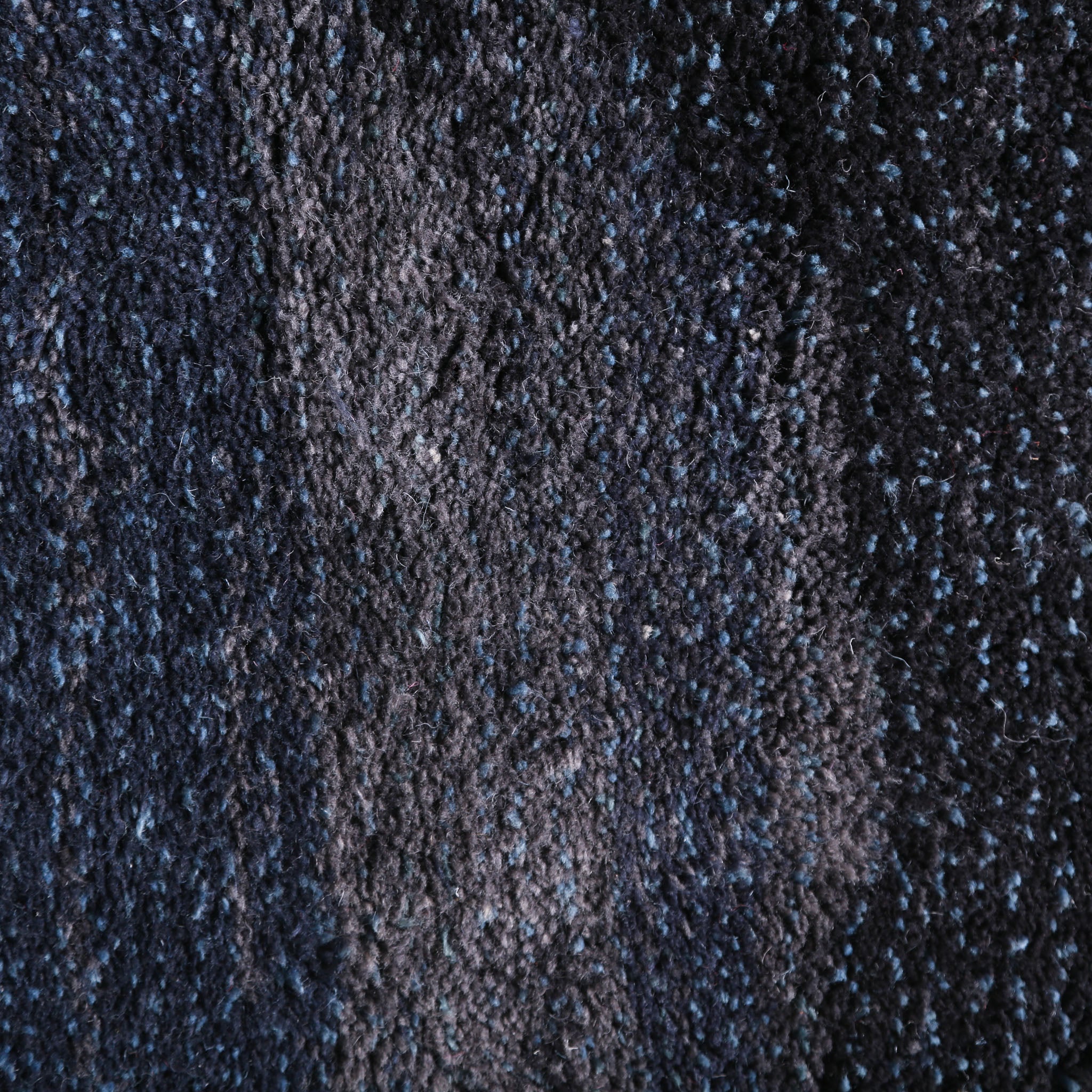 Dettaglio ravvicinato del tappeto berbero marocchino Beni Mrirt, che mostra la tessitura densa e il motivo mélange in tonalità di blu scuro e nero