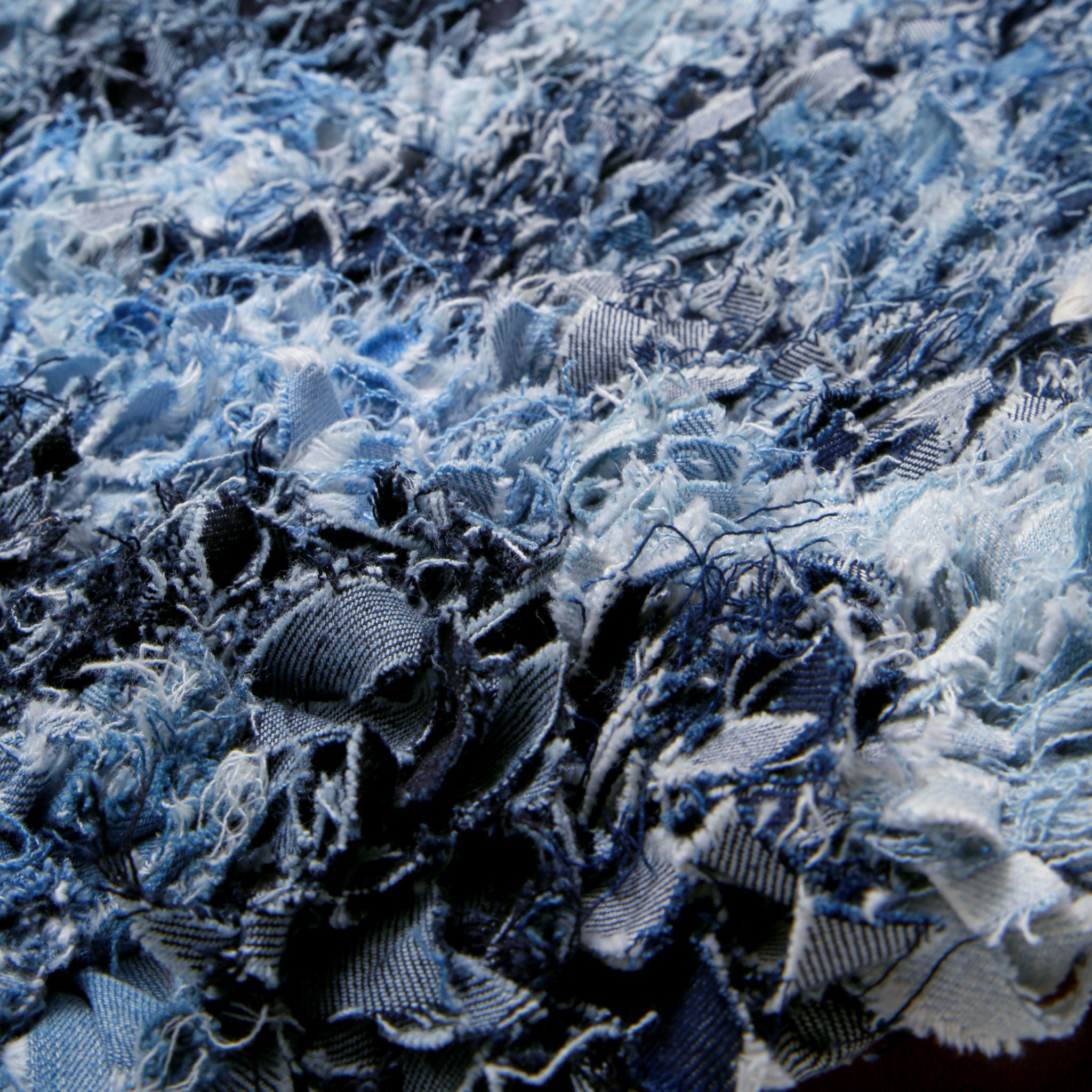 dettaglio delle fettuccine di jeans annodate di un tappeto boucherouite realizzato con vecchi jeans
