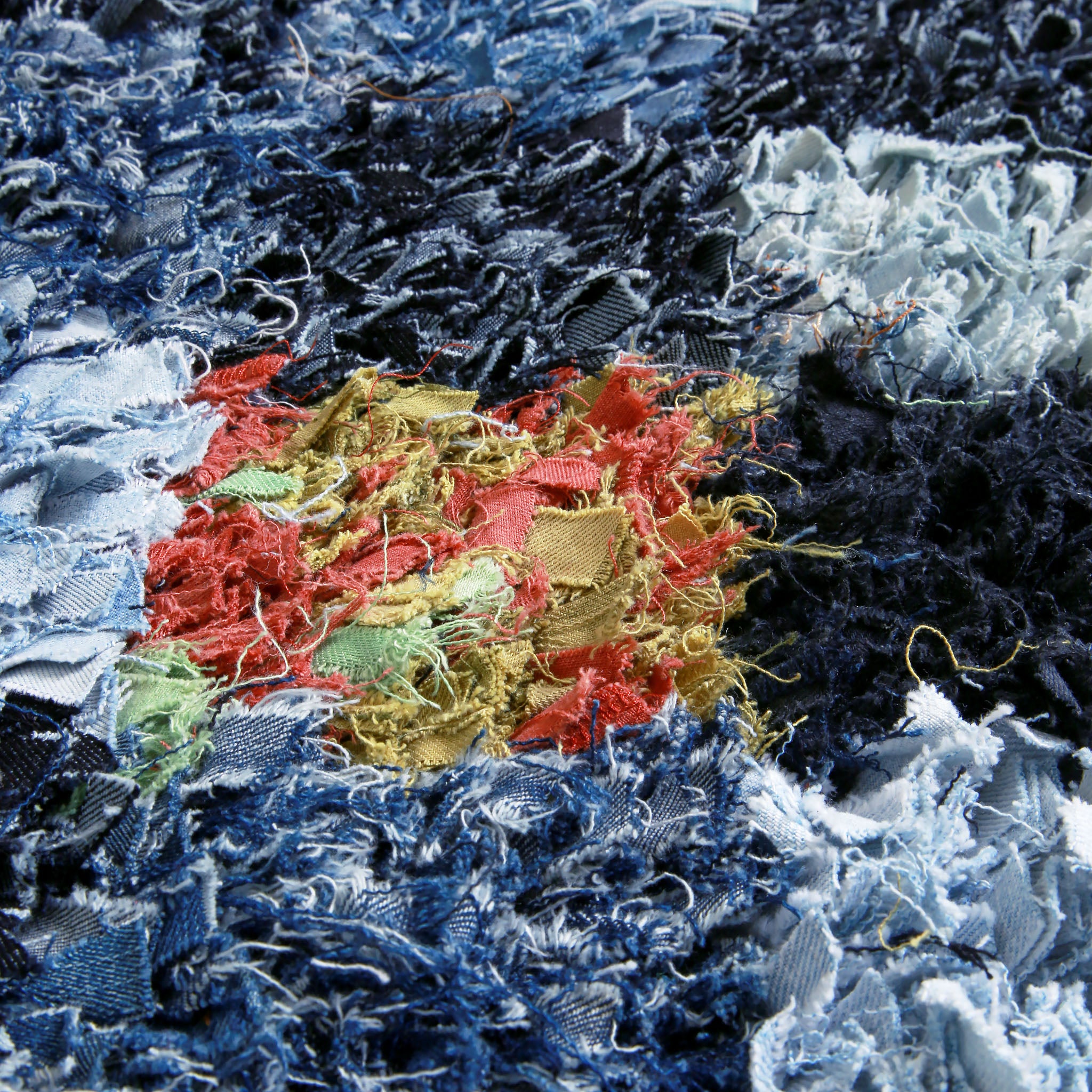 dettaglio del denim di diverso colore annodato in un tappeto