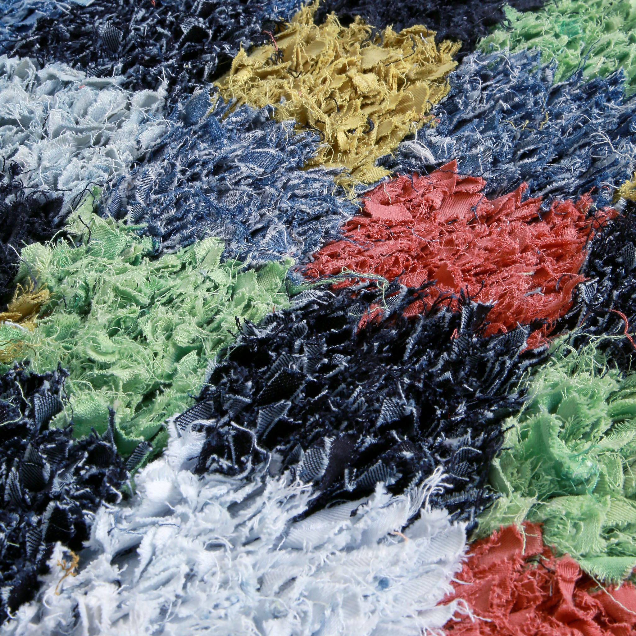 dettaglio del denim di diverso colore annodato in un tappeto