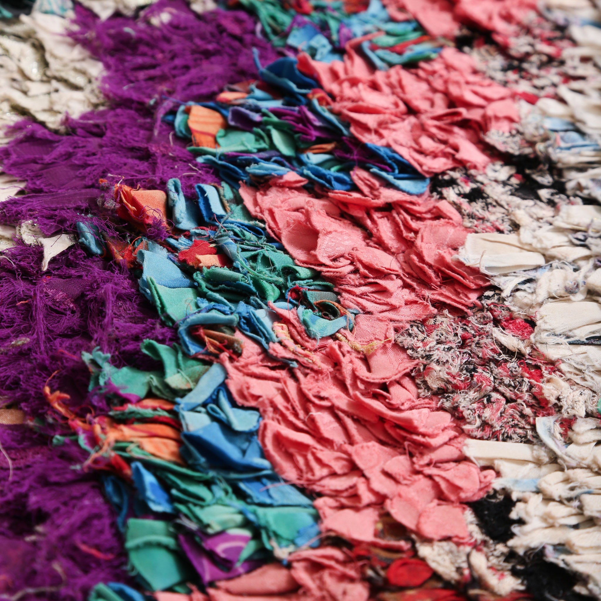 dettaglio delle fettuccine di tessute annodate che formano dei quadrati di diversi colori