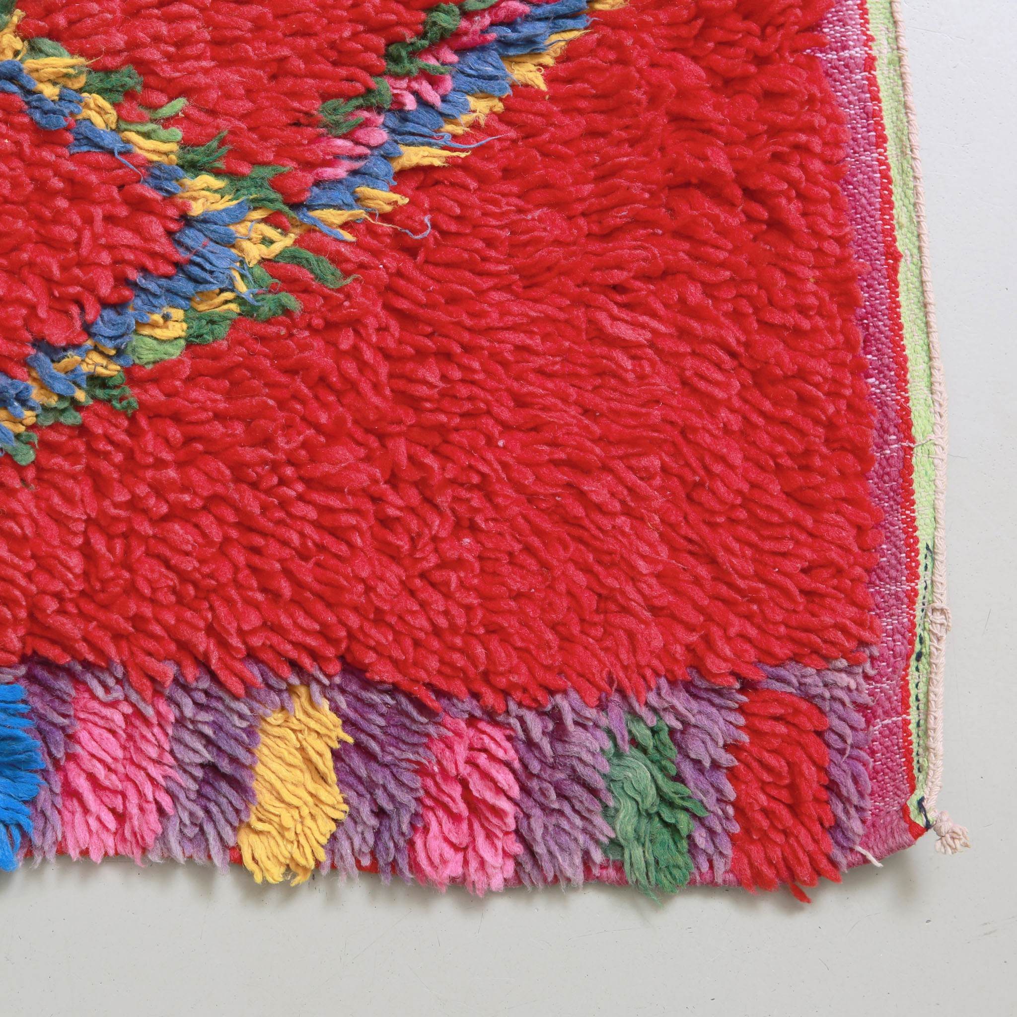 Dettaglio angolo e bordo tappeto Boujaad vintage rosso, lavorazione artigianale marocchina multicolore