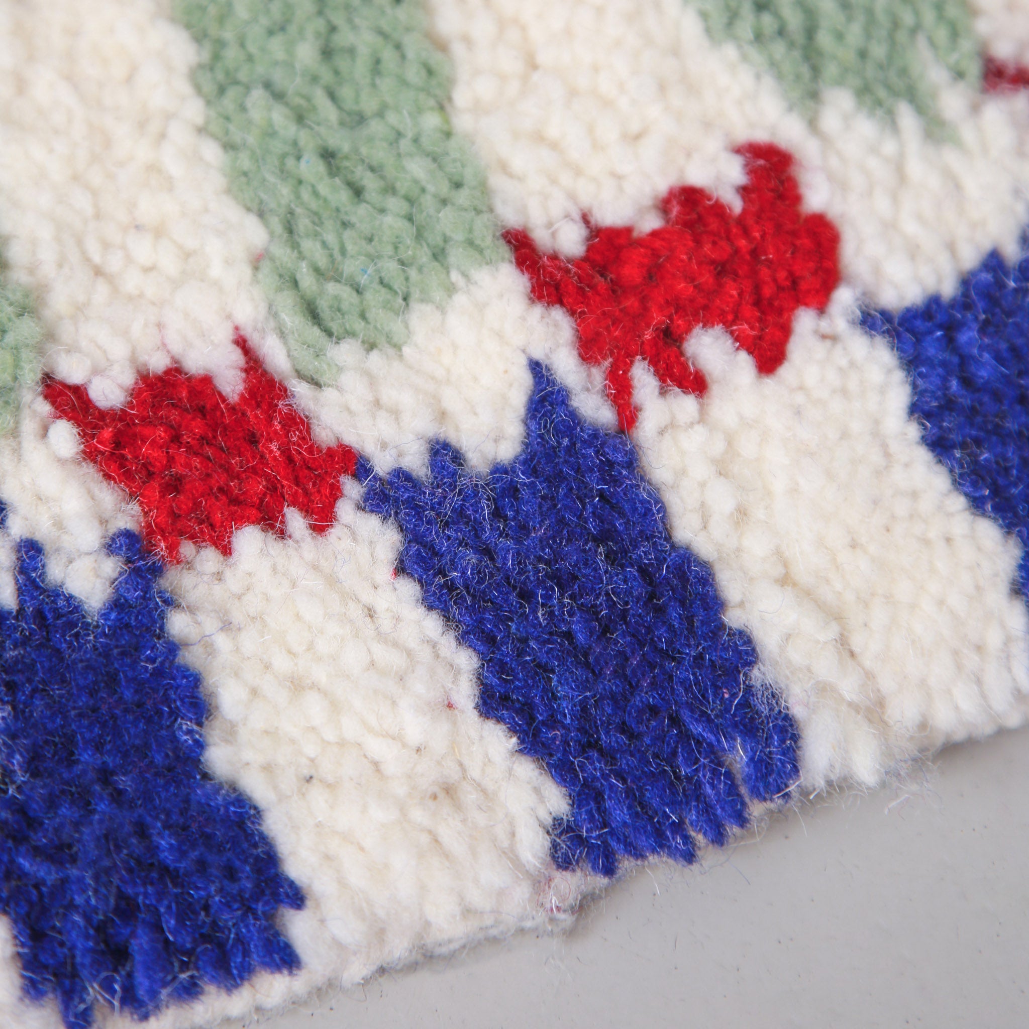 Tappeto geometrico cameretta Linhas con dettaglio colori naturali rosso, blu cobalto e verde salvia, annodato a mano da artigiane marocchine