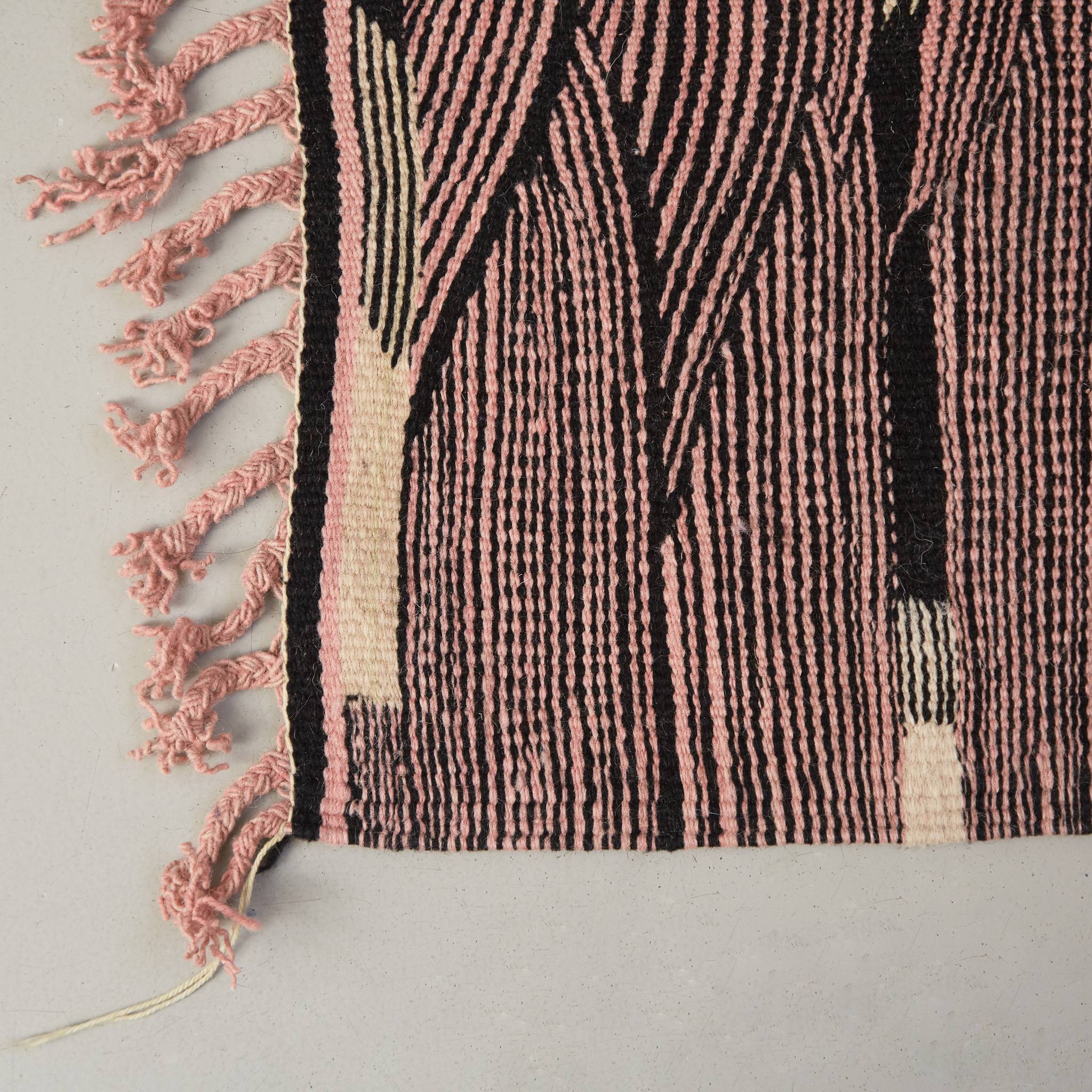 dettaglio della frangia rosa e della lavorazione di un tappeto kharita a tessitura piatta realizzando intrecciando lana nera e rosa