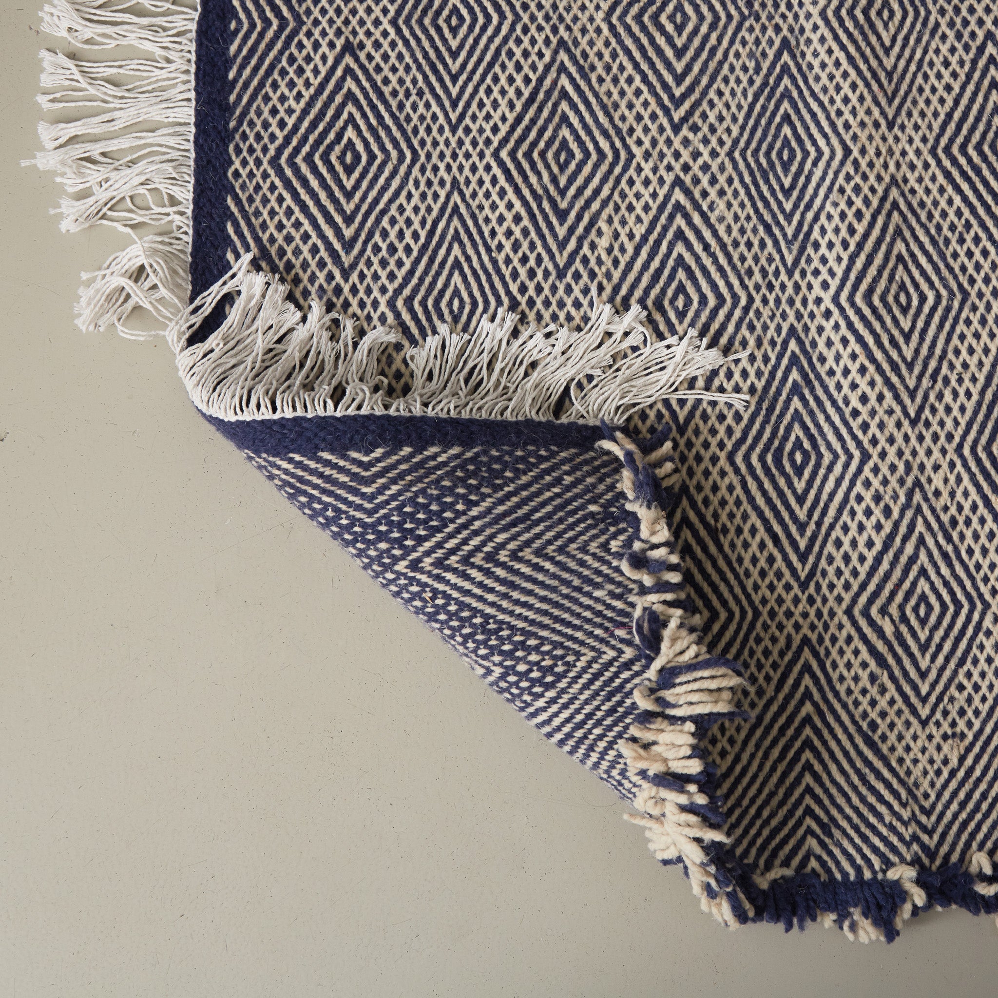 dettaglio del retro di un tappeto zanafi kilim realizzato intrecciando lana color bianco e indigo creando dei rombi