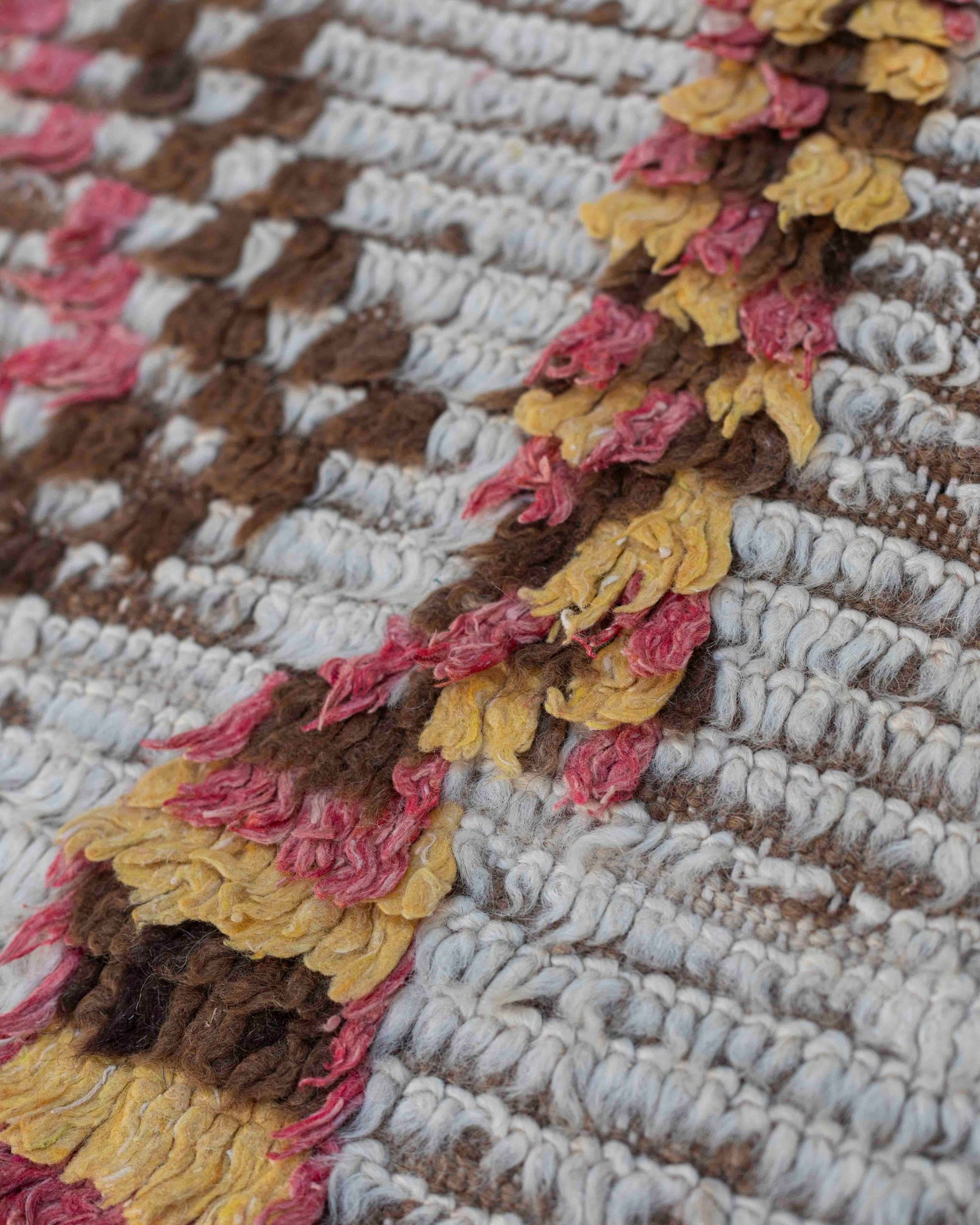 Texture ravvicinata della lana della passatoia Azilal vintage con disegni ocra, rosso-rosati e marroni