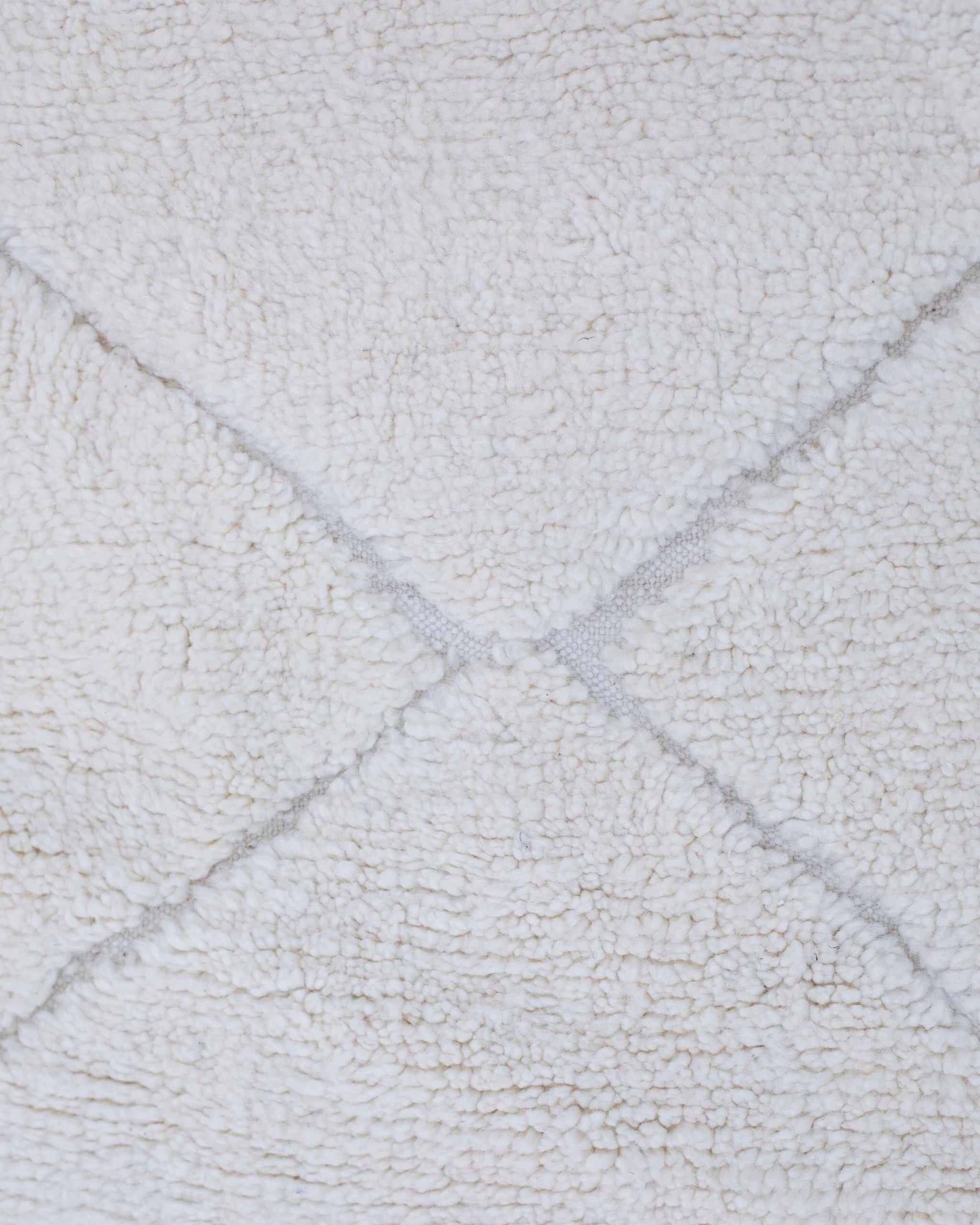 Texture ravvicinata del tappeto Beni Ourain bianco con rombi tono su tono e lana morbida