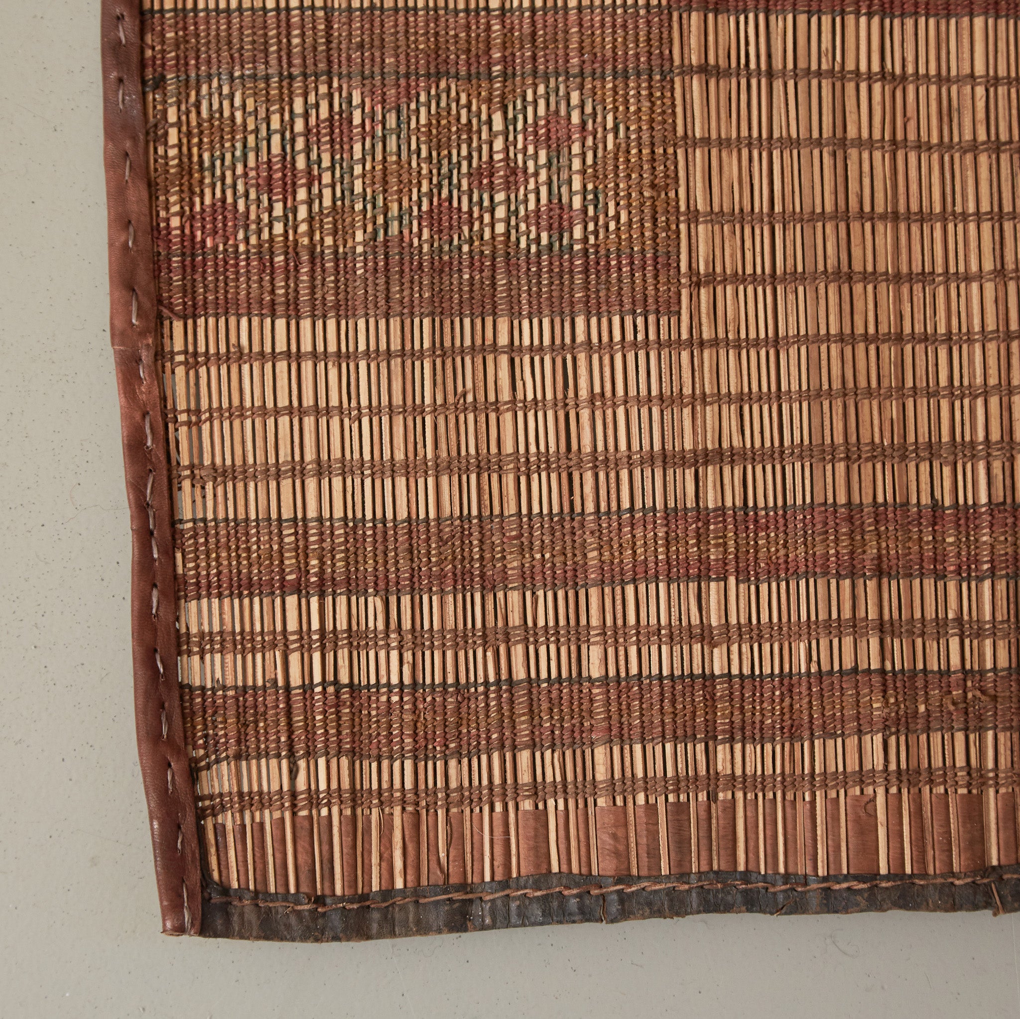 dettaglio dell'angolo di una Stuoia touareg vintage in legno e cuoio