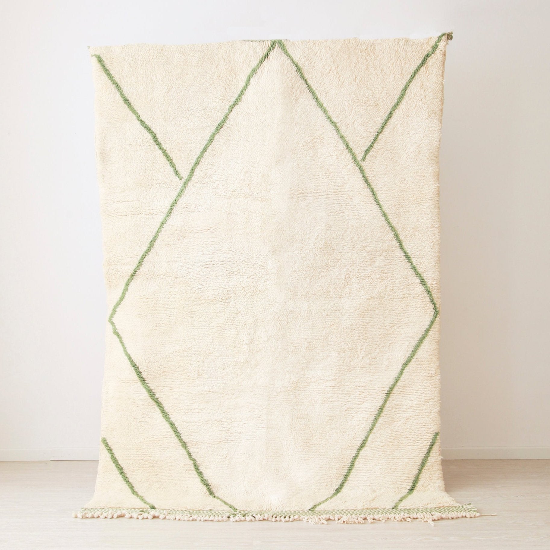tappeto beni mrirt realizzato in lana bianca con linee verde. Le linee creano una grande rombo