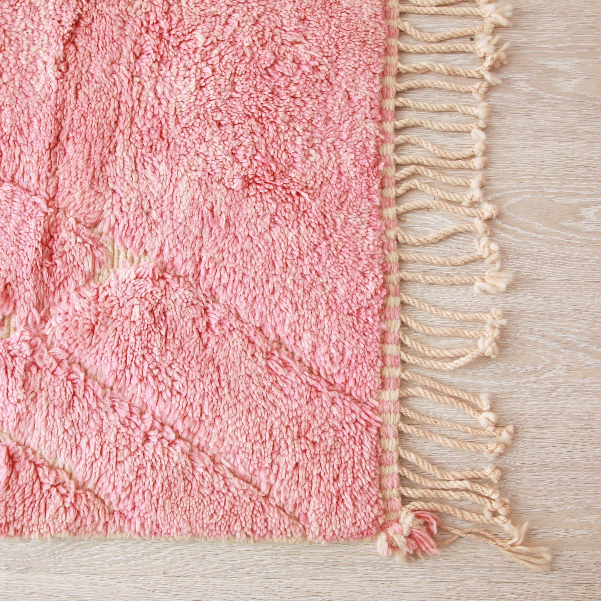Angolo di un tappeto beni mrit rosa per mettere in evidenza la frangia