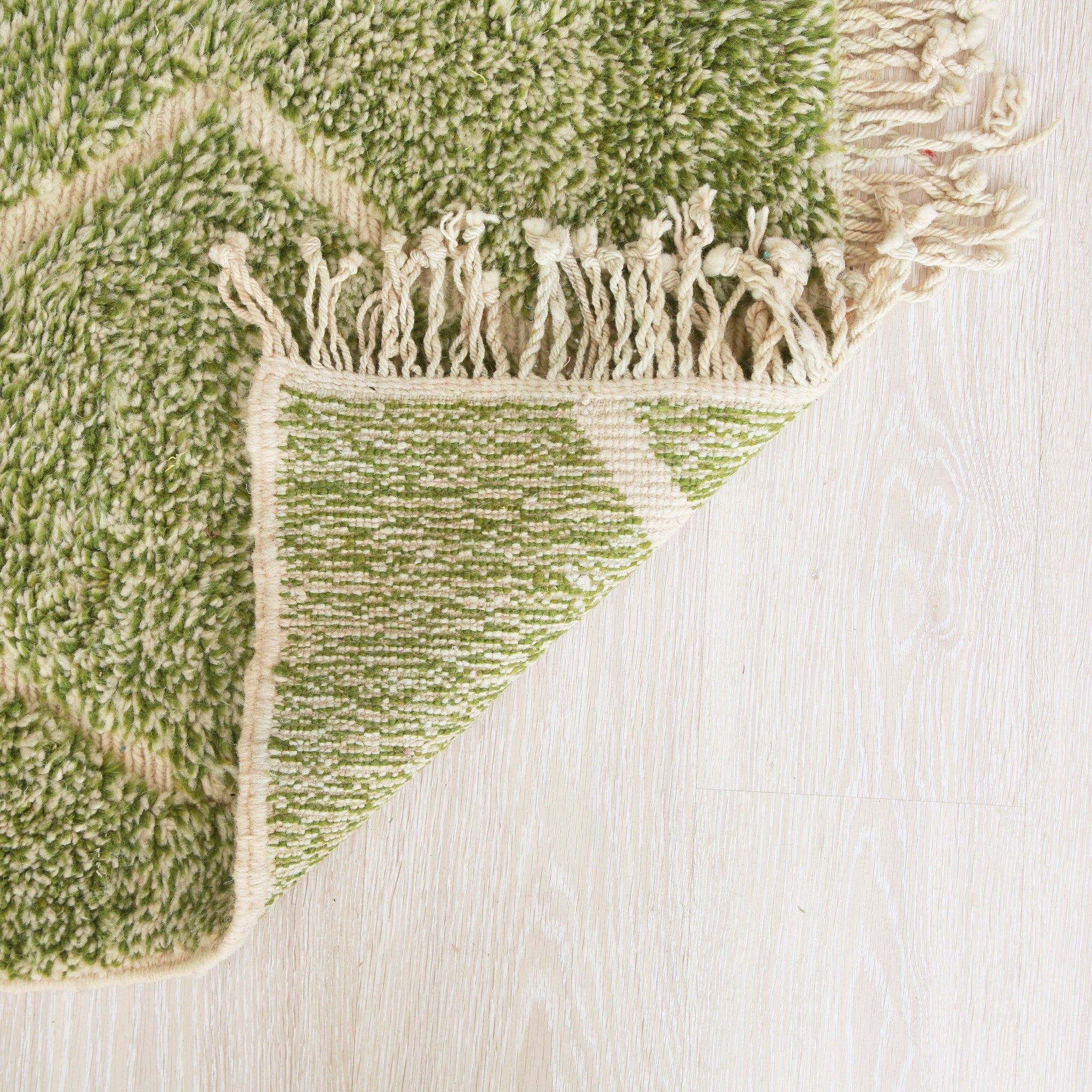 retro di un tappeto beni mrirt che l'alternanza di nodi verdi e bianchi nonché i nodi in tessuto chiaro che creano le linee visibili sul tappeto