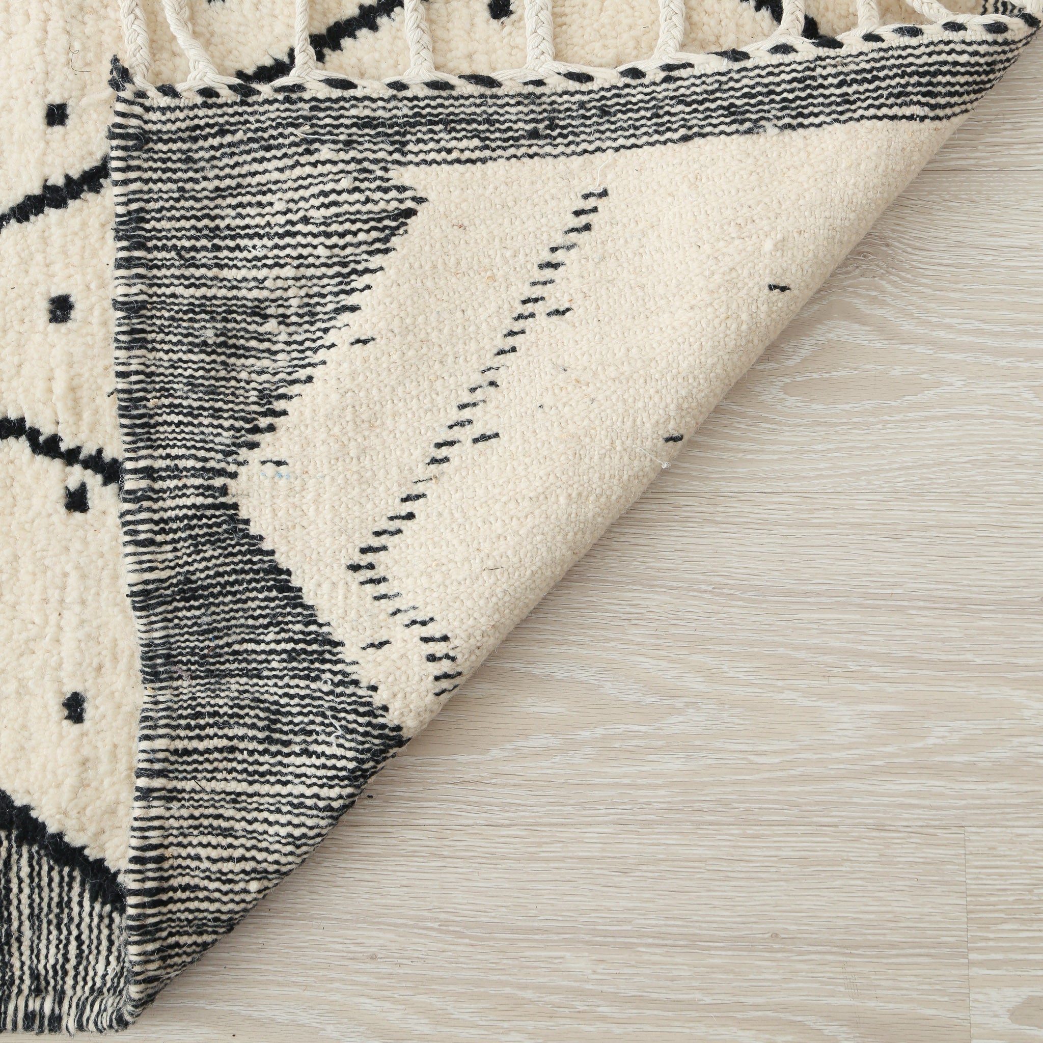 tappeto beni ourain con disegni geometrici a rombi e pois neri e lati scuri dettaglio del retro
