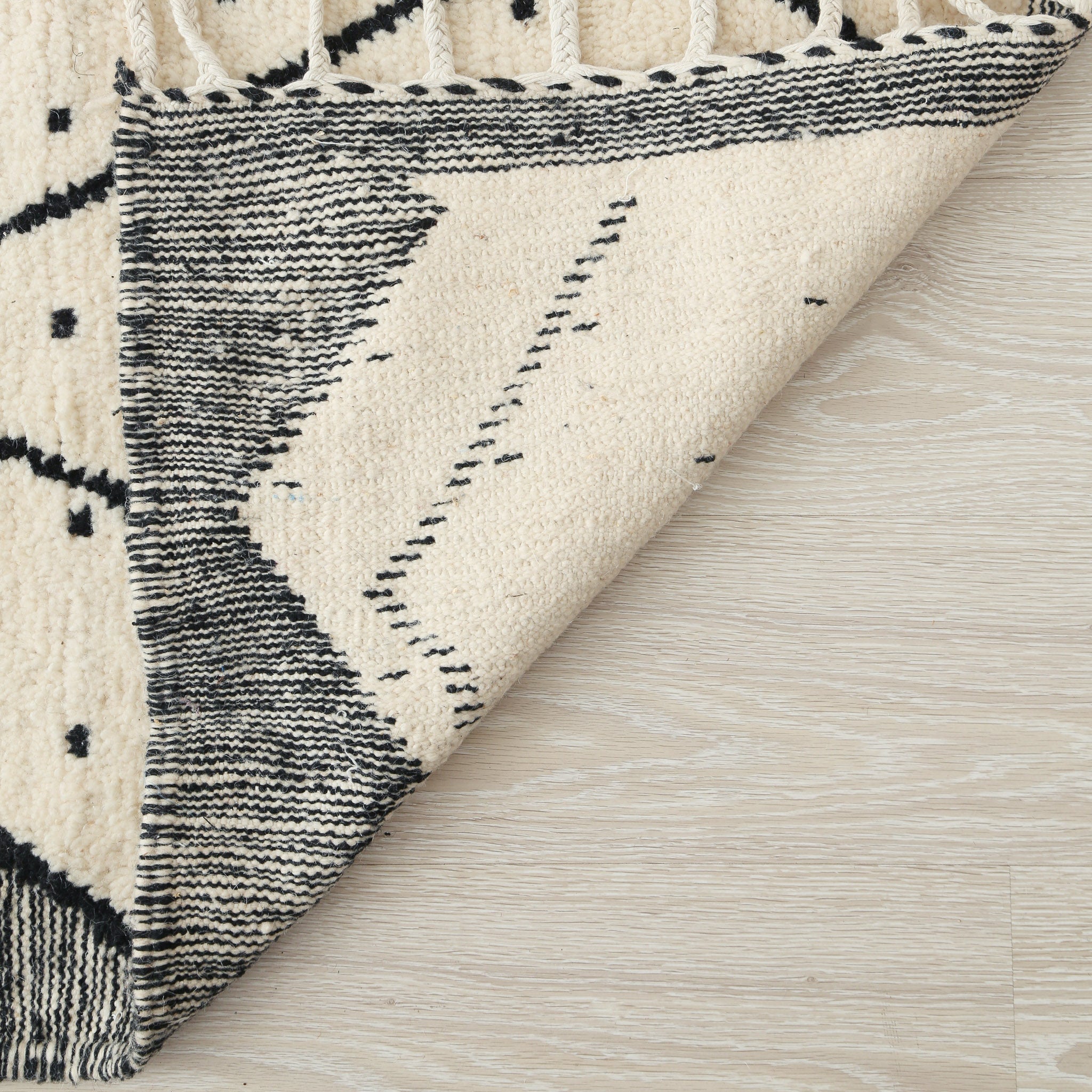 tappeto beni ourain con disegni geometrici a rombi e pois neri  e lati scuri dettaglio del retro