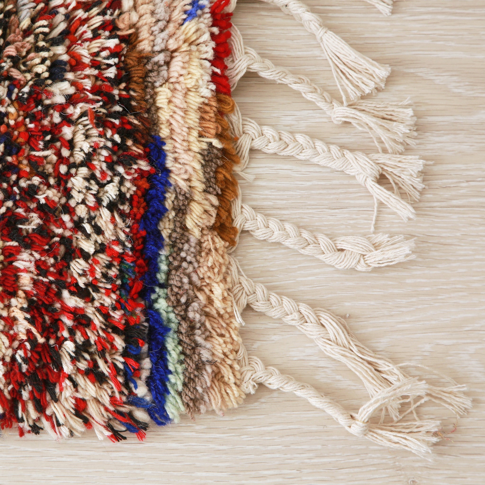 angolo e frangia bianca di un tappeto boucherouite realizzato con avanzi di tessuti e di filati di diversi colori