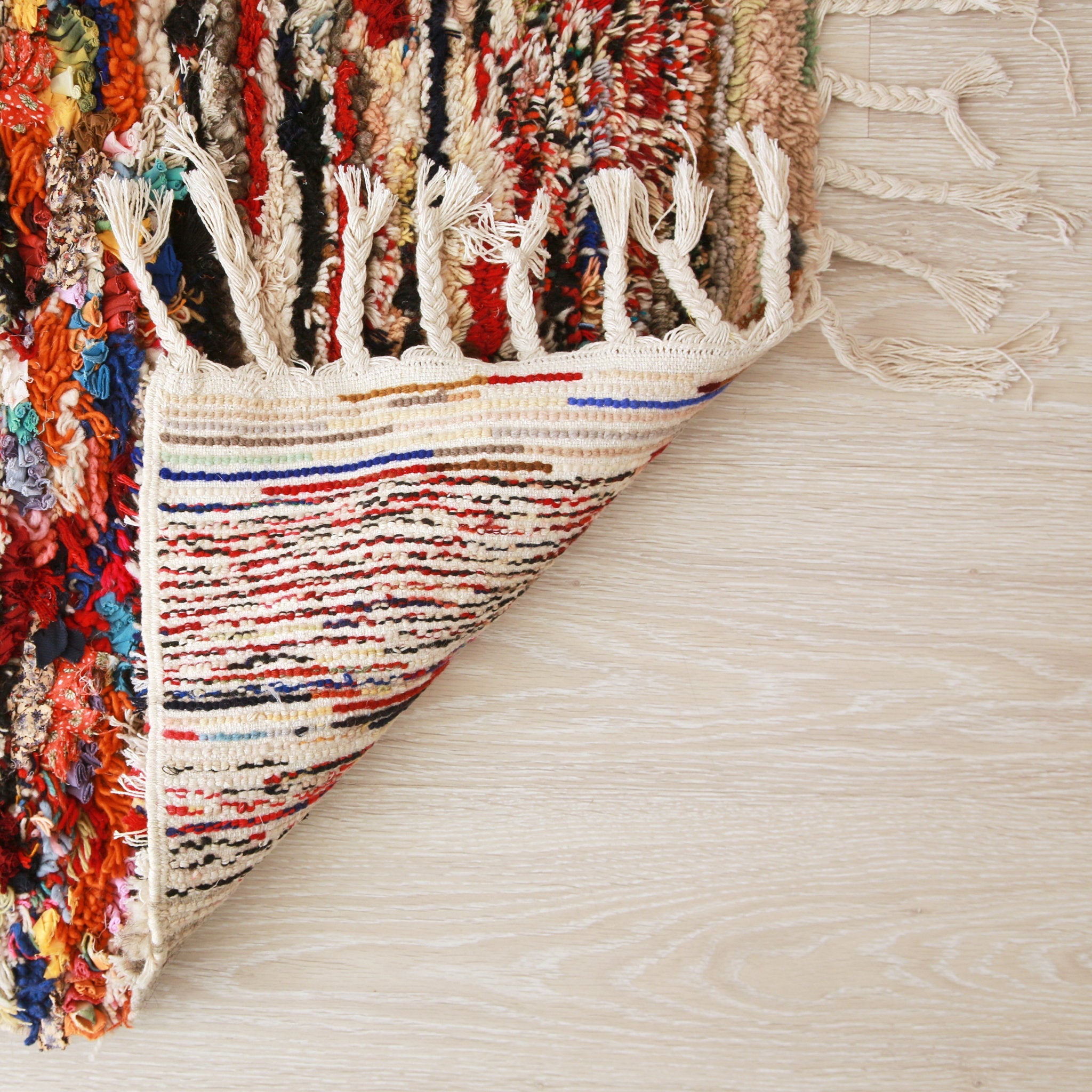 retro dell'angolo di un tappeto boucherouite realizzato con avanzi di tessuti e di filati di diversi colori